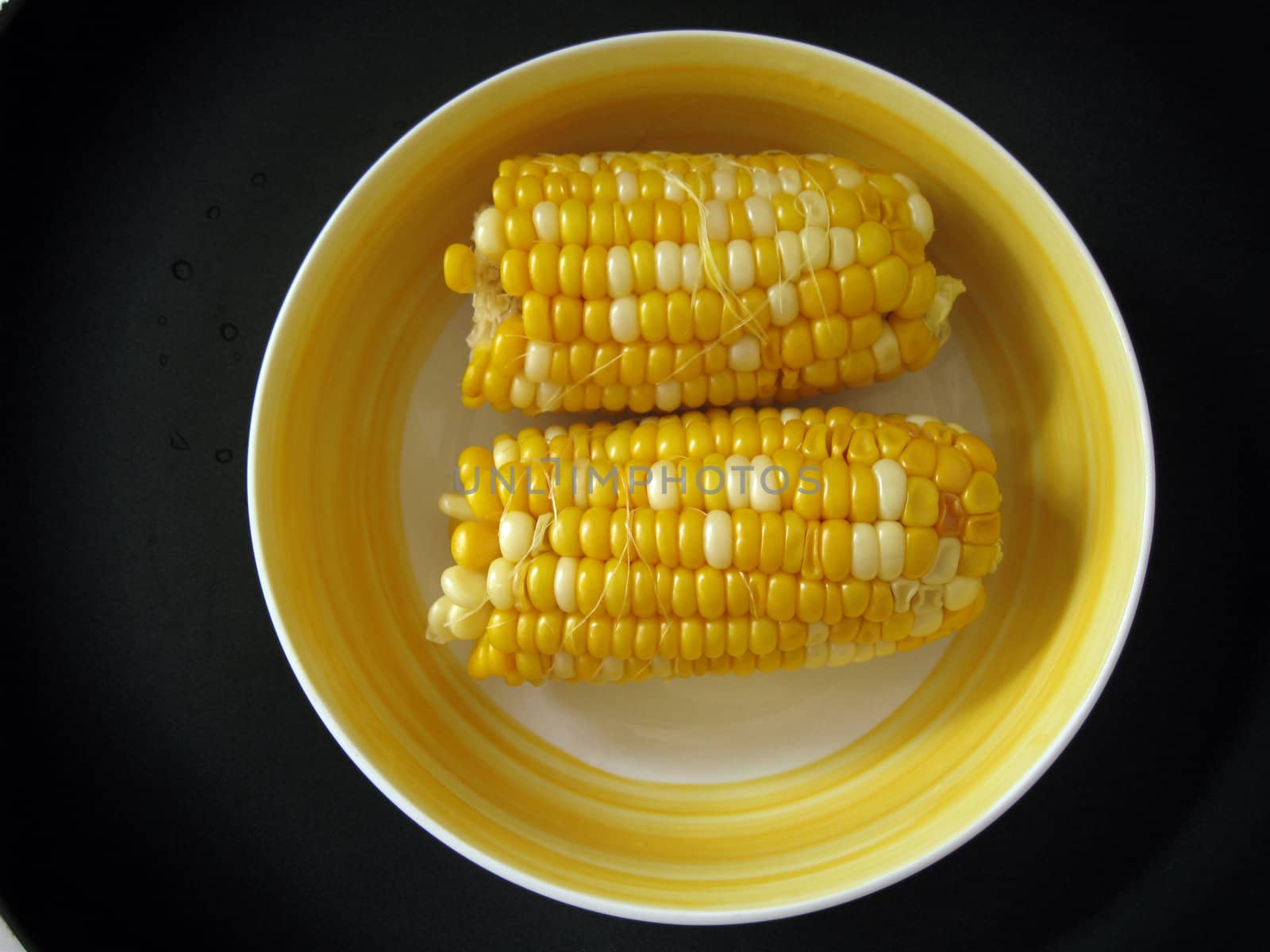 top view of 2 sweet corn in a bowl