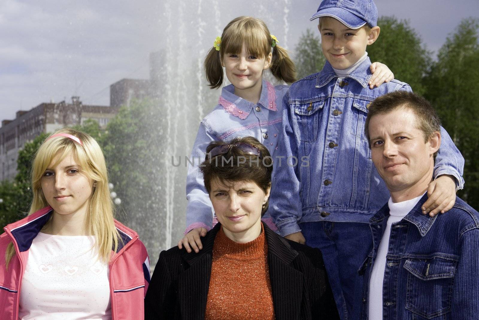 Family against a fountain and the sky with clouds