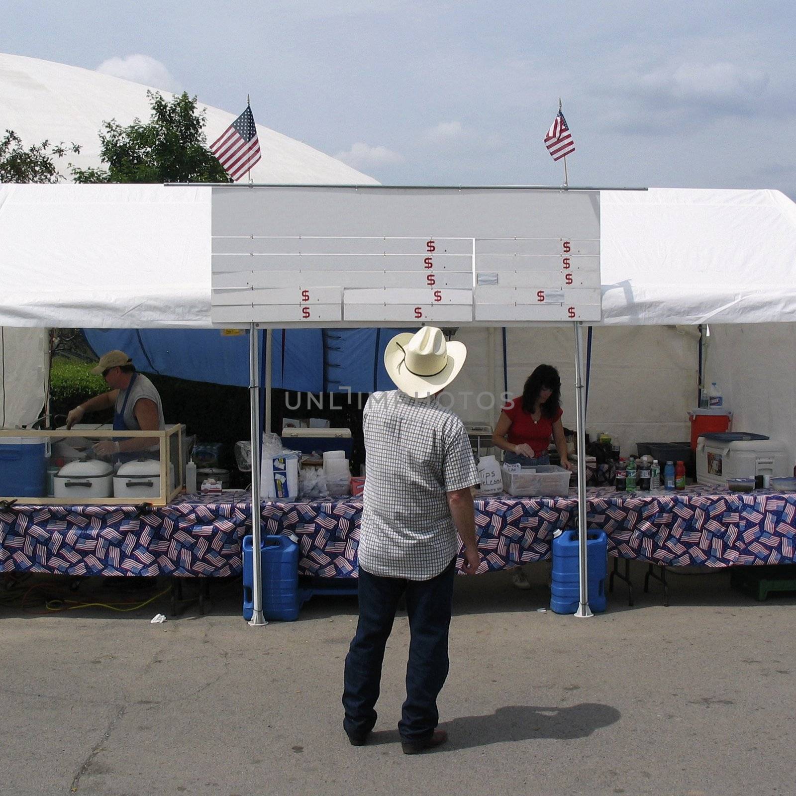 American cowboy standing in front of a blank menu board