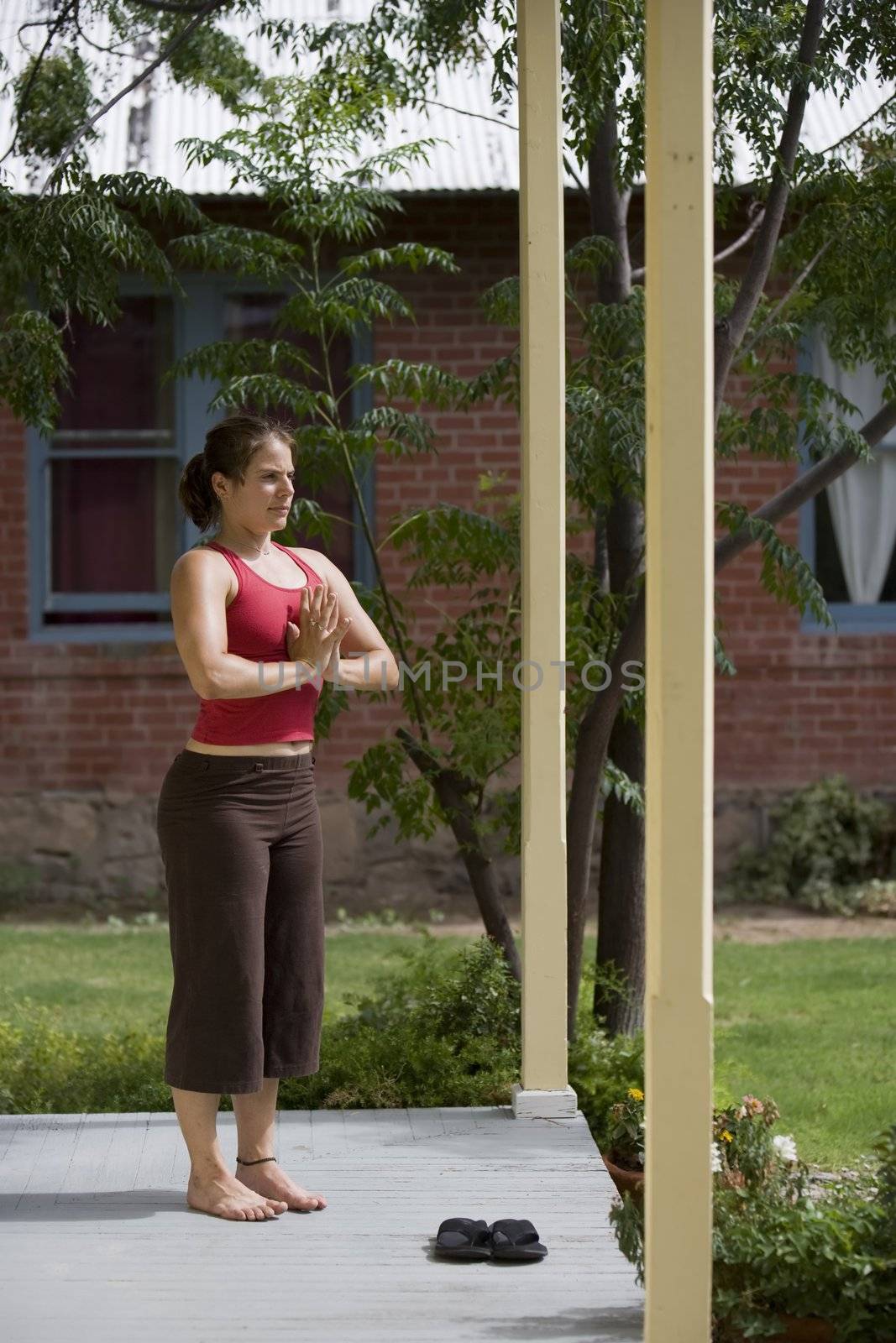 Pretty Young Woman doing Yoga on a Porch