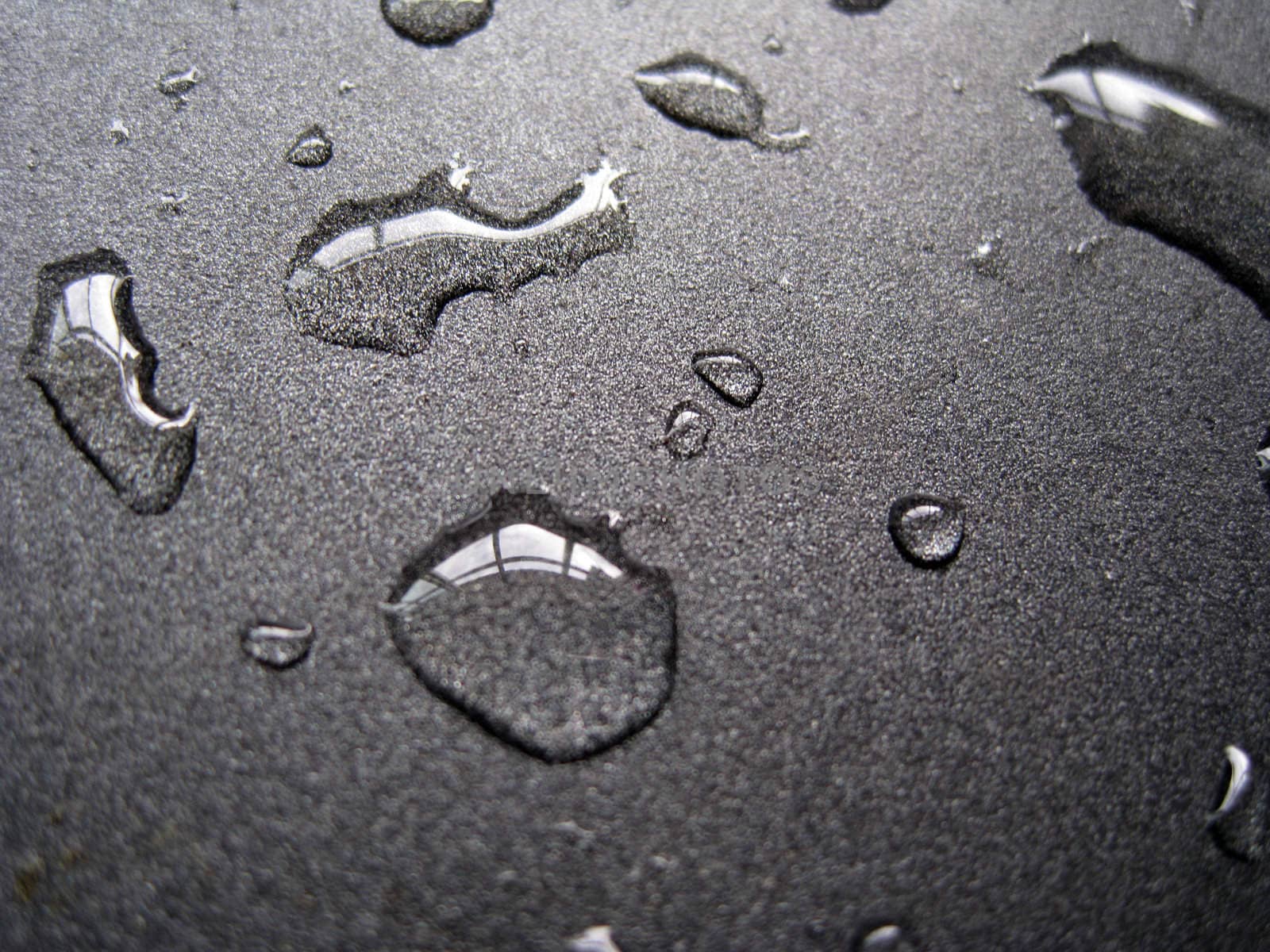 close up for a few water drops on a metallic surface