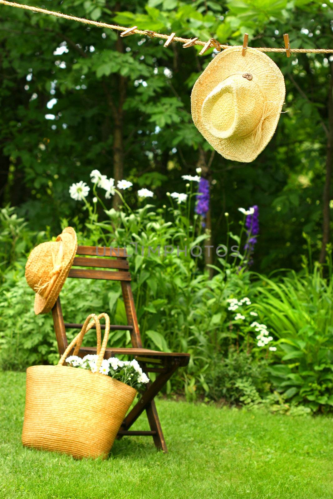 Straw hat hanging on clothesline by Sandralise