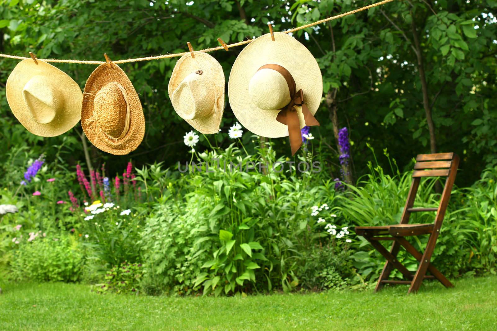 Summer straw hats hanging on old clothesline
