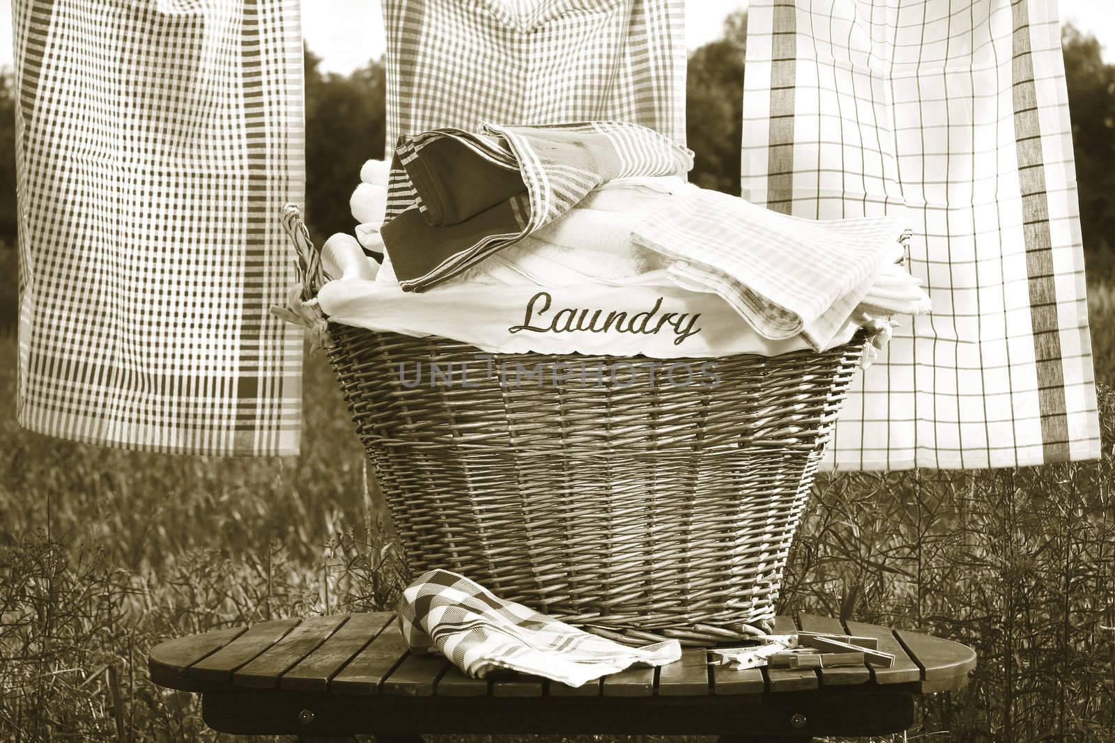 Laundry basket on rustic table with clothesline/ Sepia tone