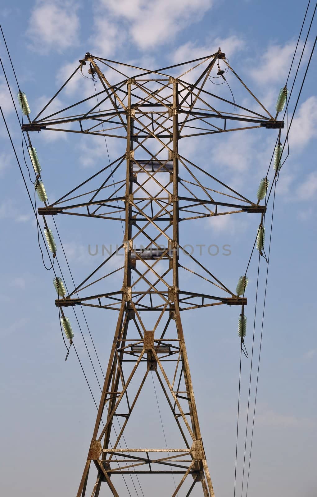 Power transmission pole against blue sky, view from below