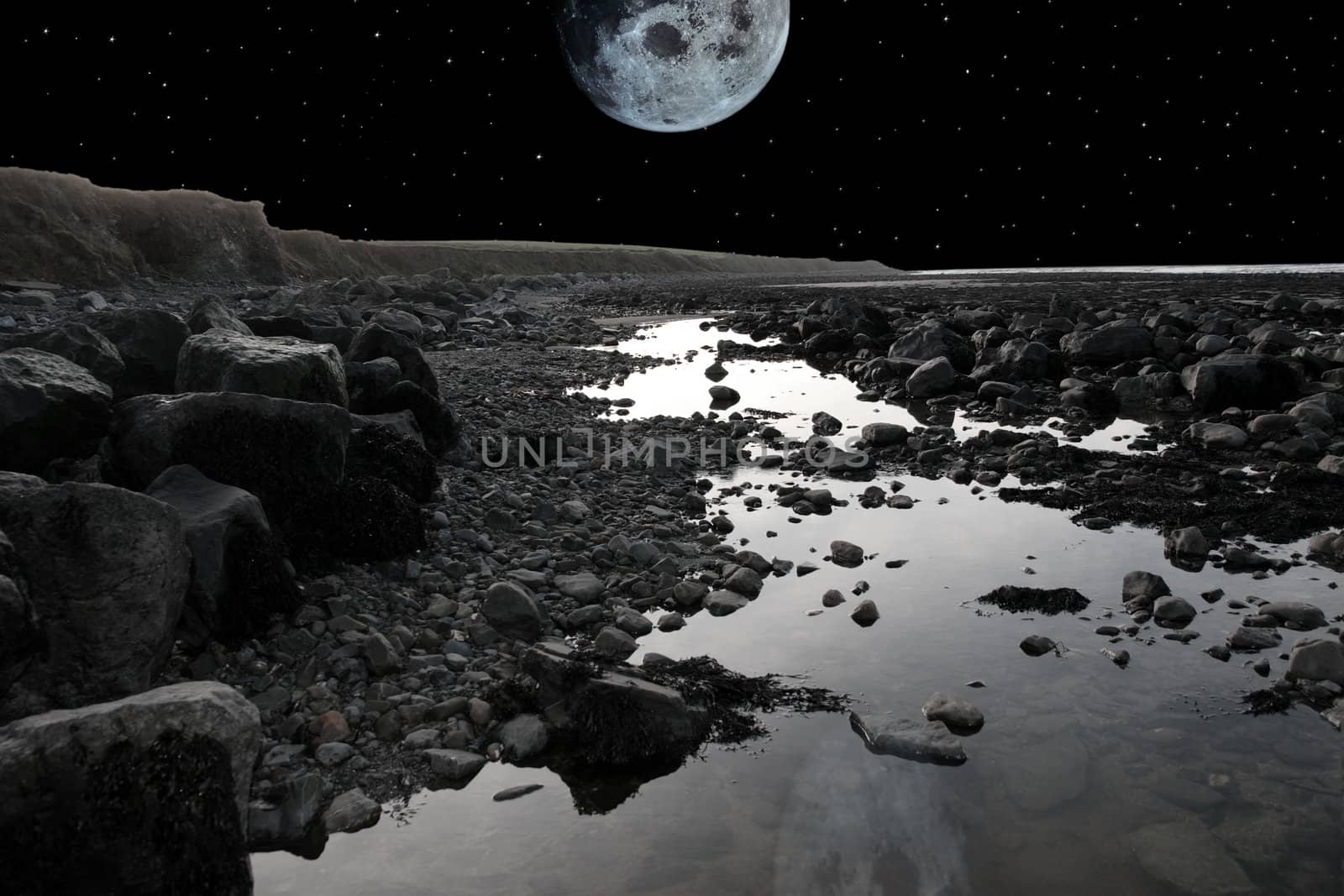 grey boulders and rocks on beale beach co kerry ireland on a cold winters night under a full moon