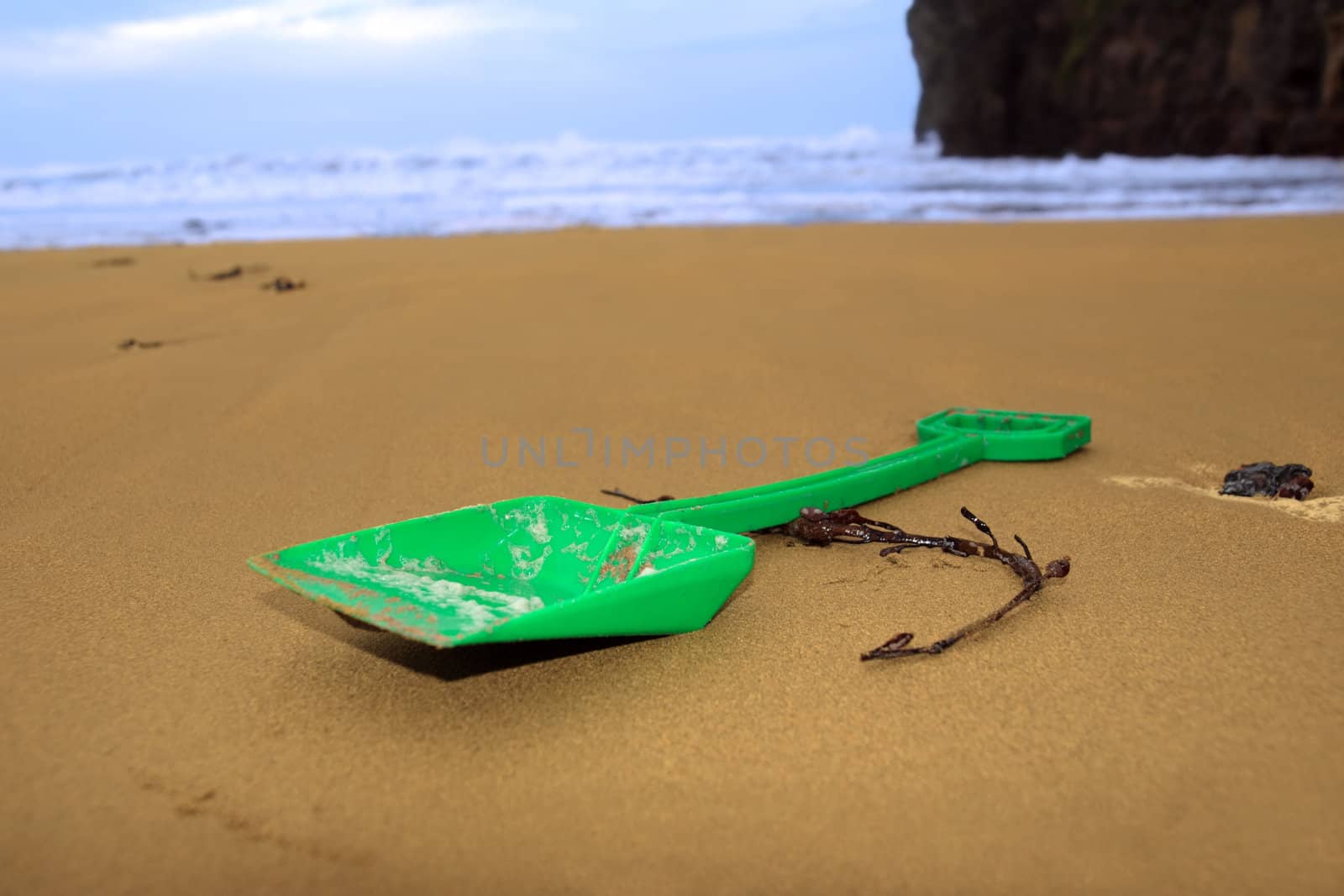 green plastic spade abandoned lying on a beach in ireland