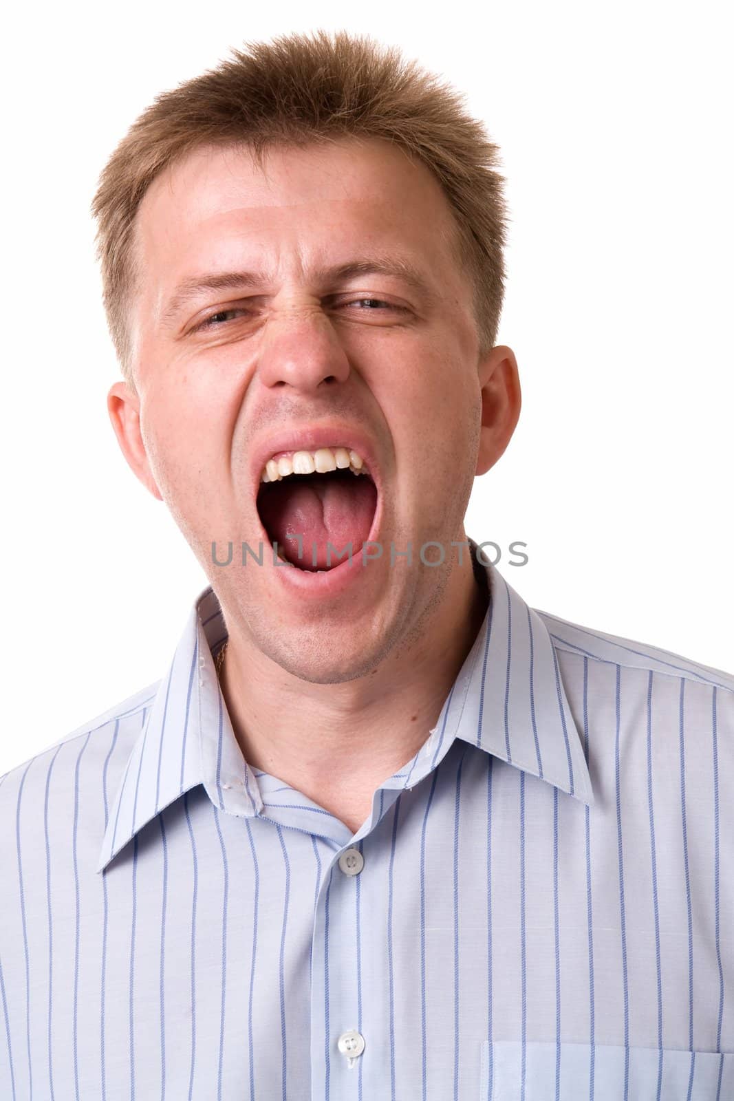 young man yawns on a white background.