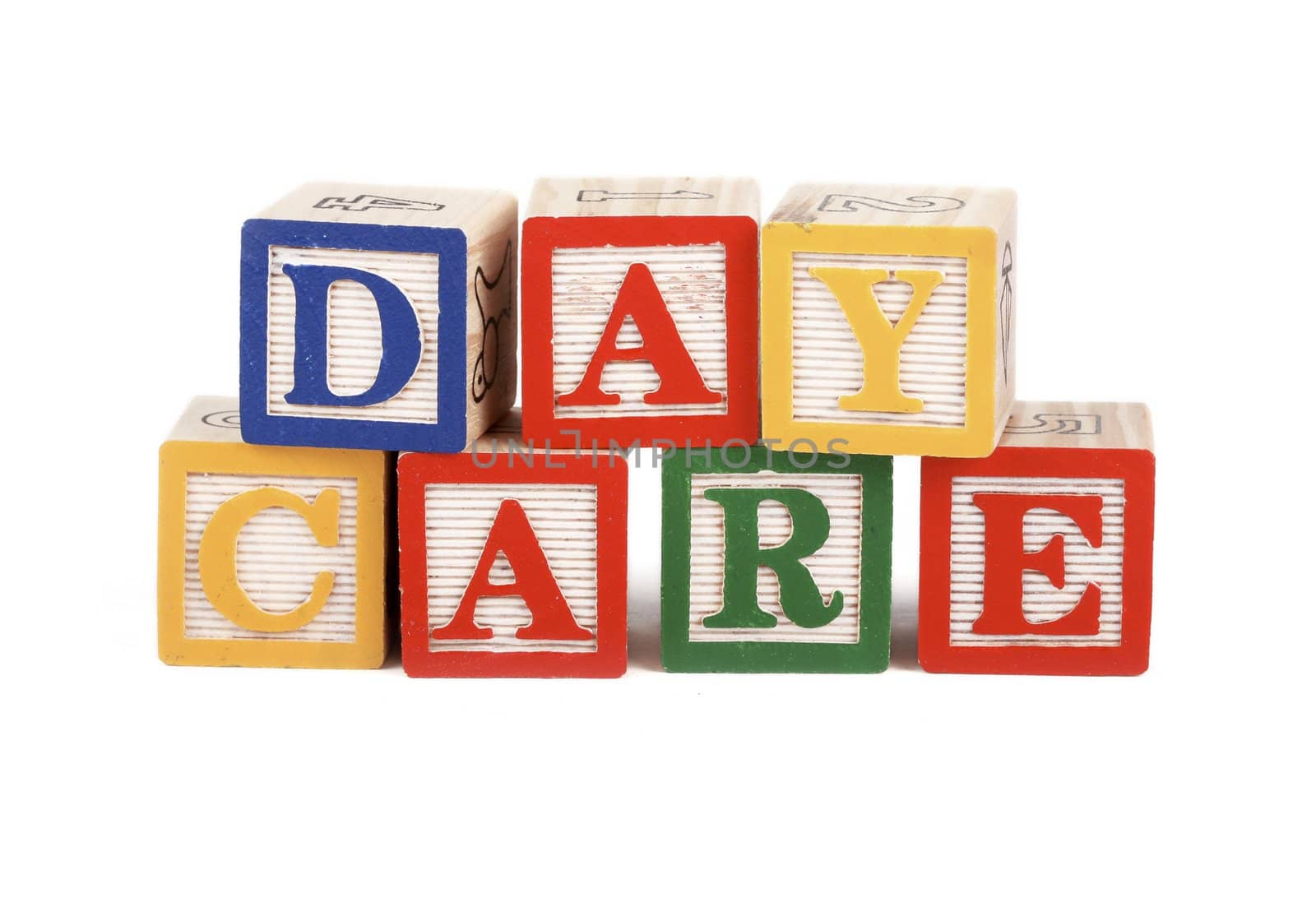 Alphabet blocks lined up to spell the word daycare isolated on white