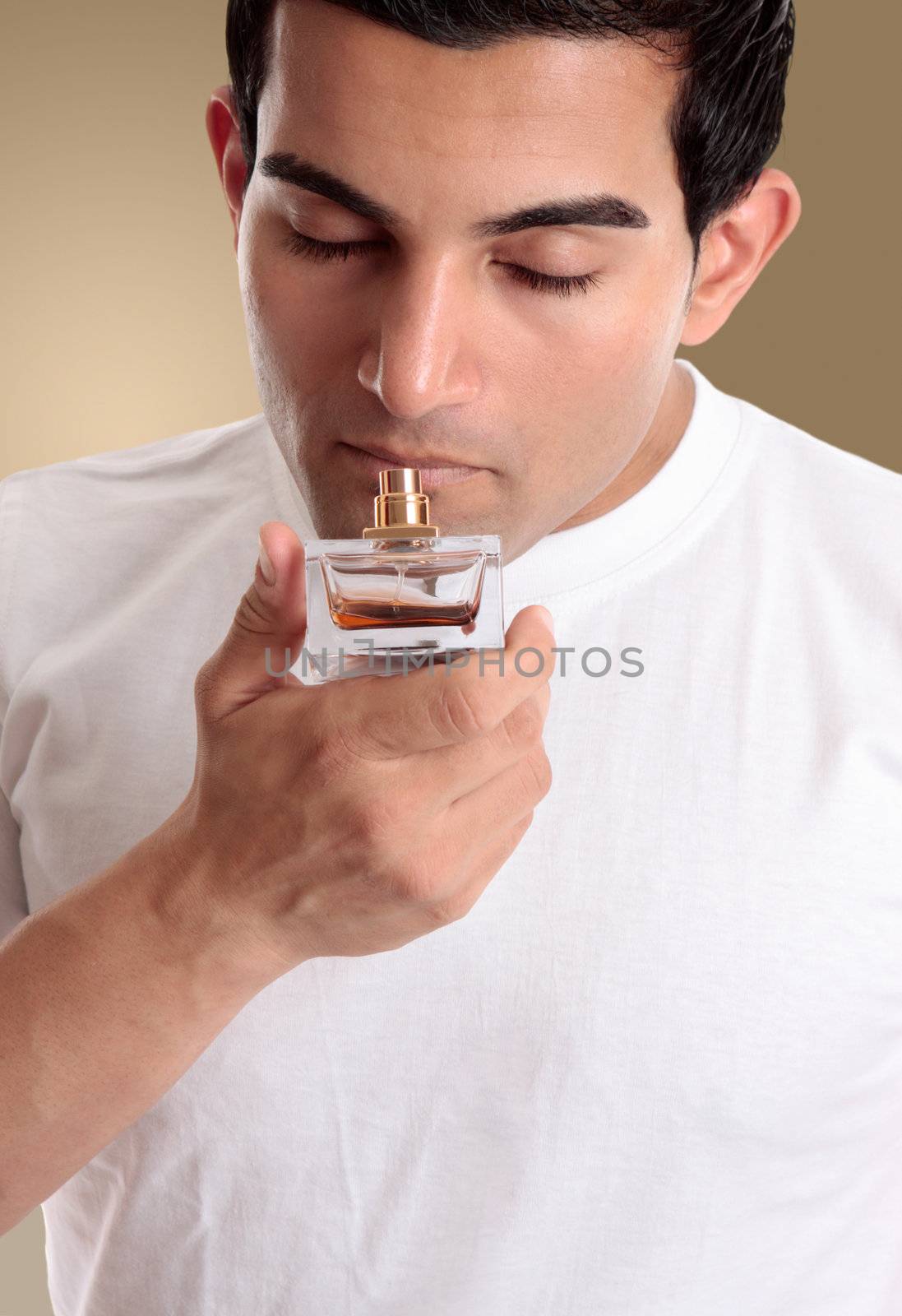 A man or customer smells the fragrant scent from a bottle of perfume or cologne.