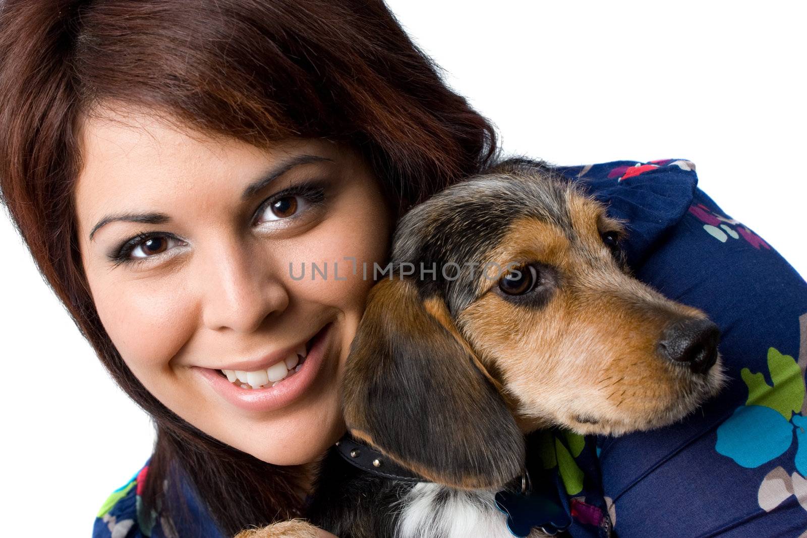 A young girl holding a cute mixed breed beagle yorkie dog isolated on a white background. 