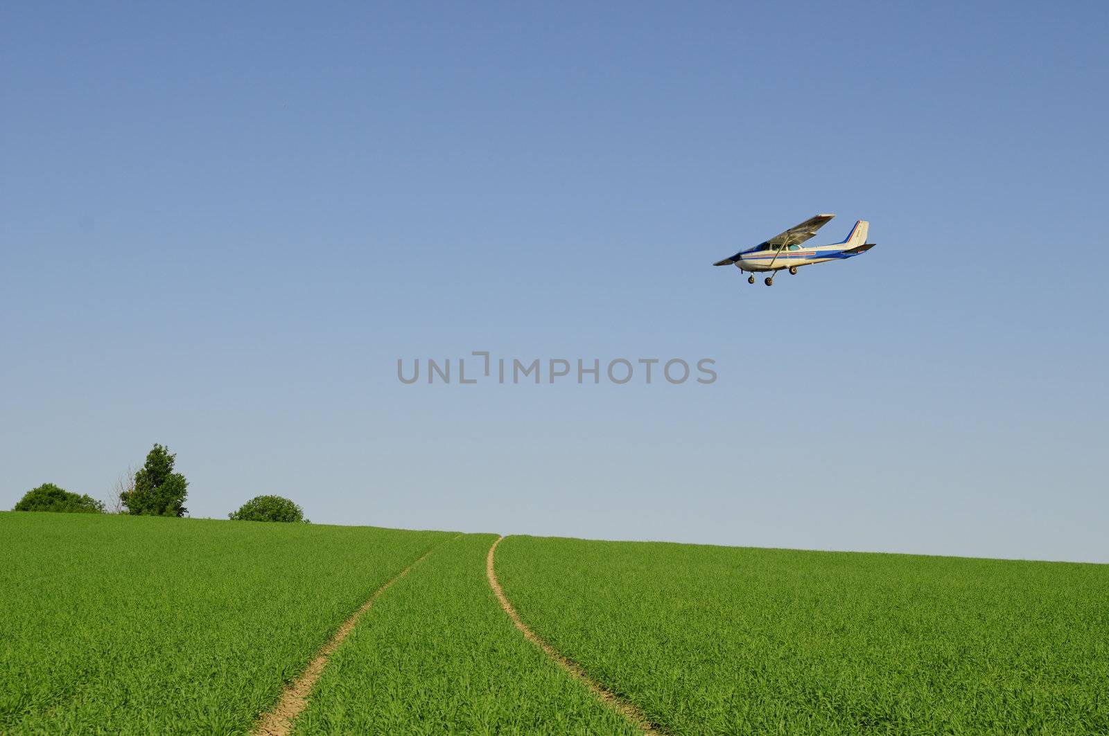 perfect green farmland with small airplane flying over