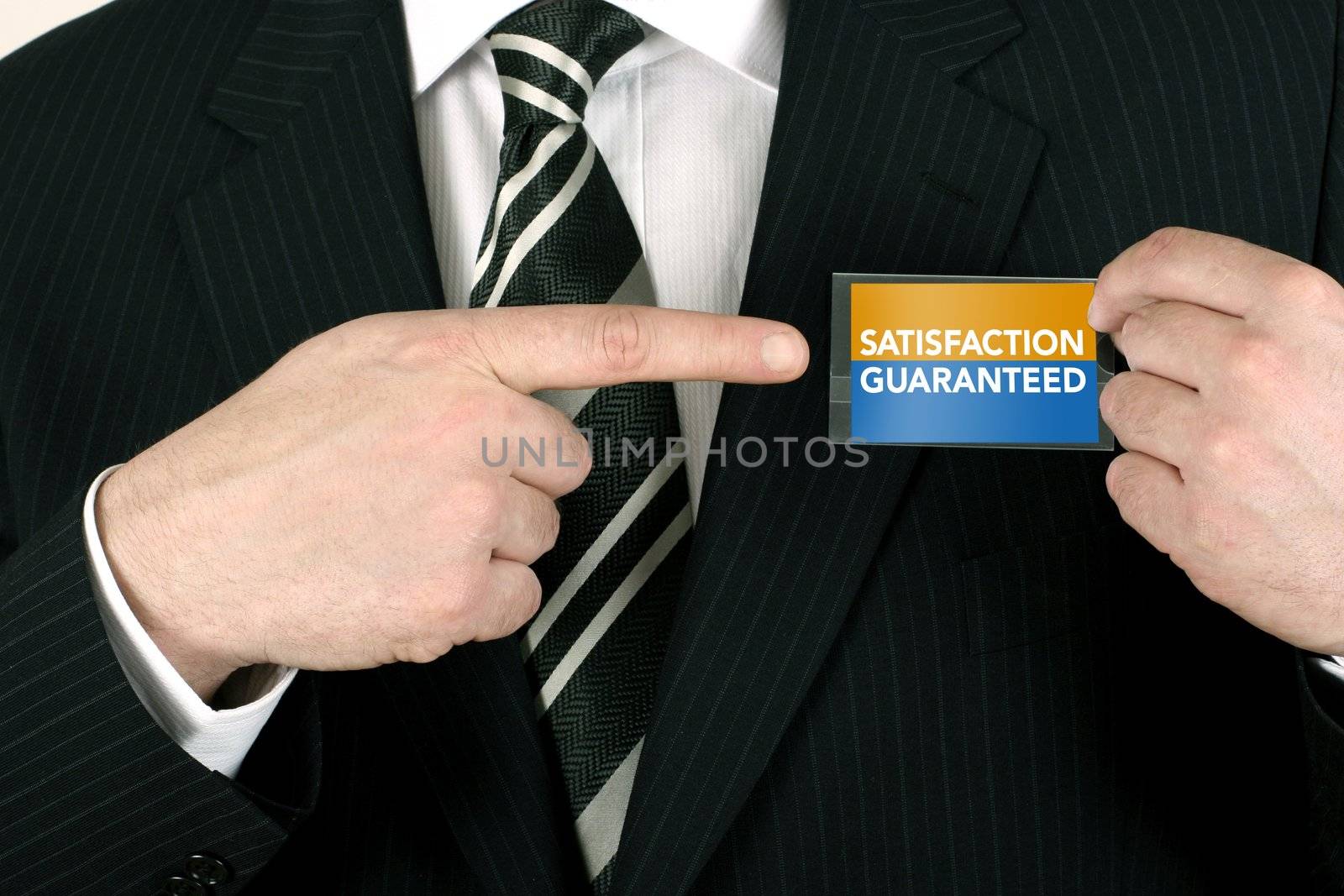 Business man making a sale pointing to a satisfaction guaranteed badge