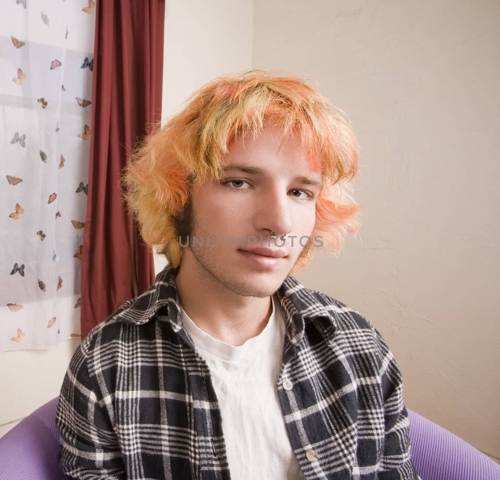 Closeup of a Young man with Bright Hair in a Bare Room