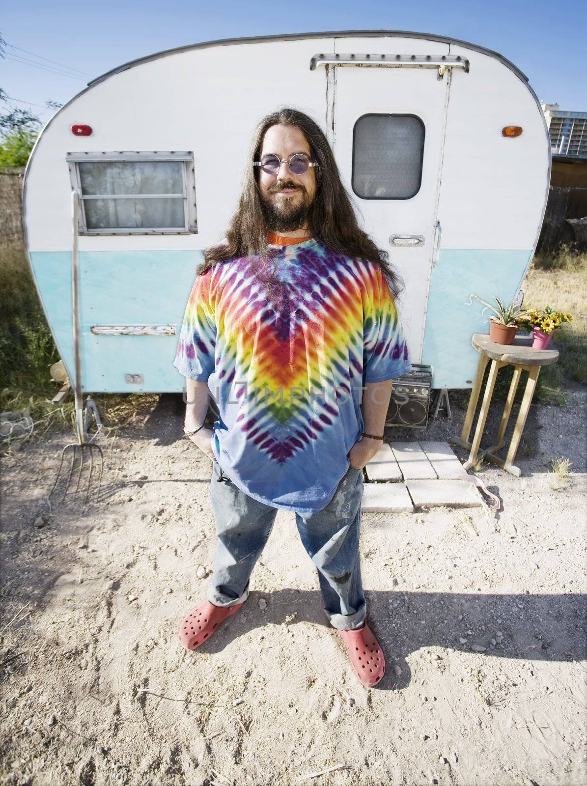 Friendly Hippie with Long Hairin Front of His Trailer