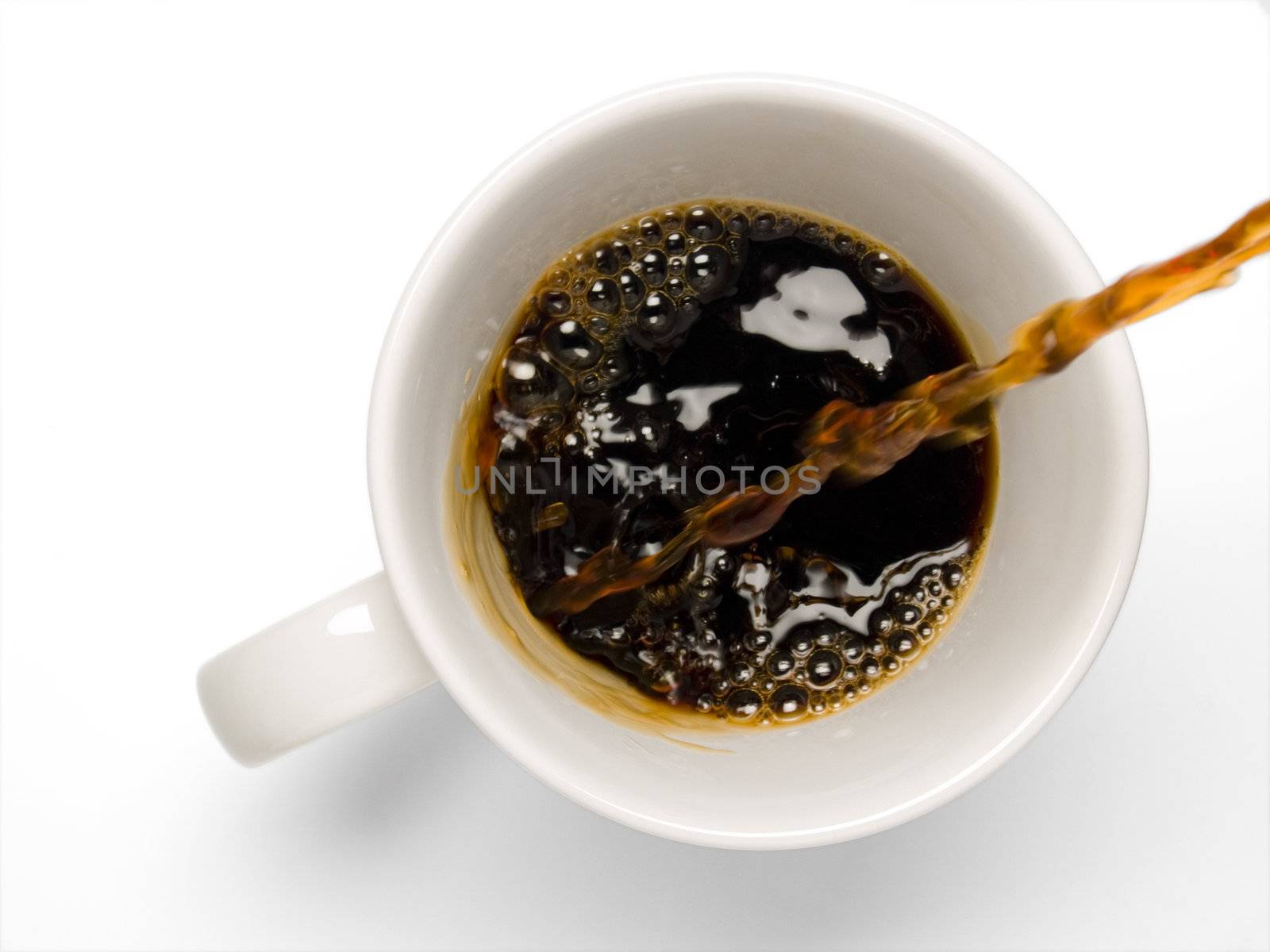 Fresh coffee being poured into a coffee cup on a white background.