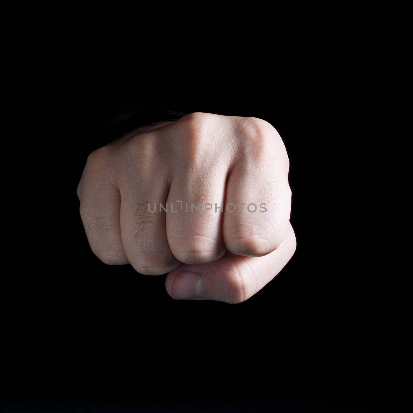 A male�s fist isolated on black background.