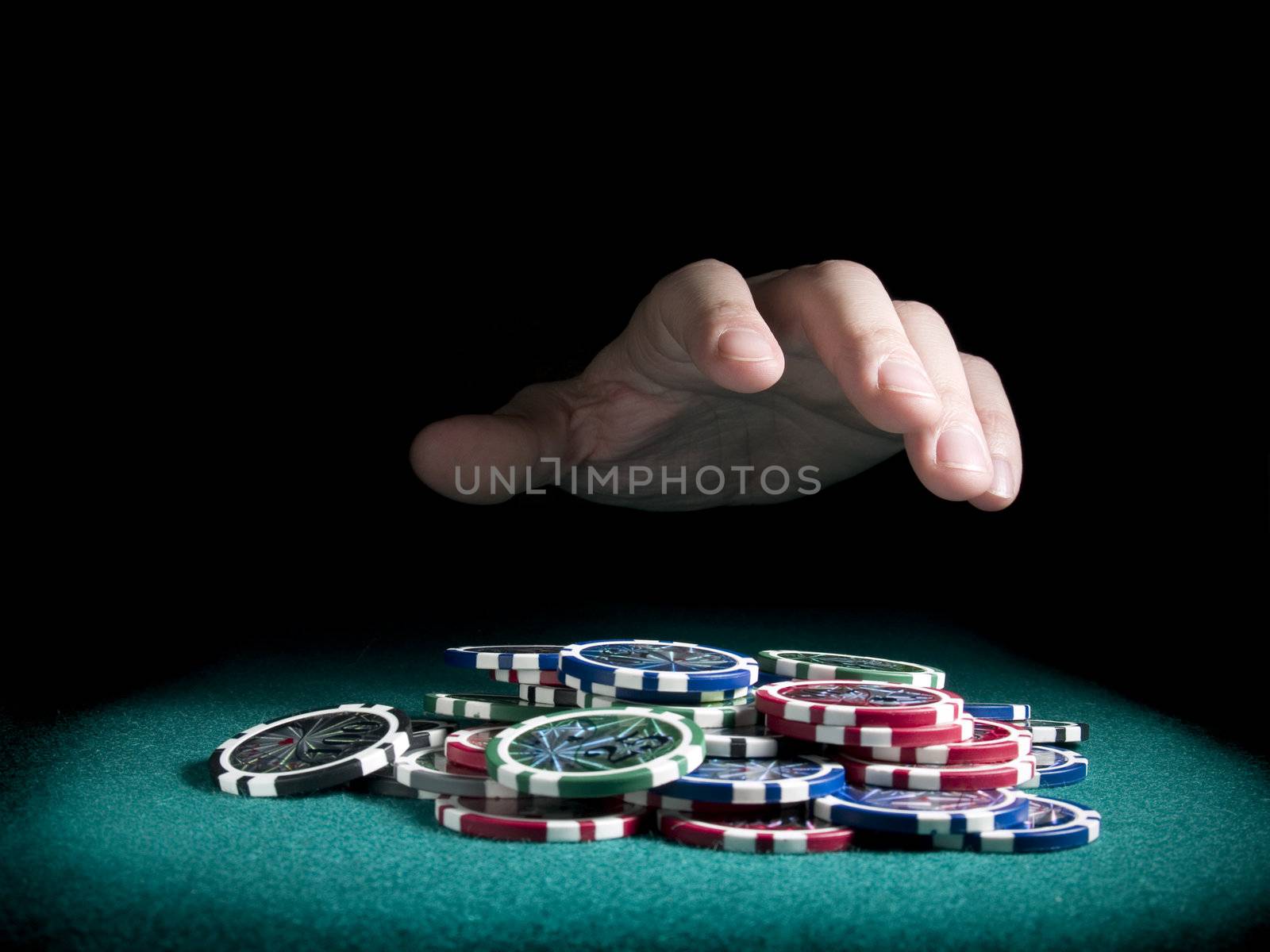 A hand about to rake a big pile of chips.