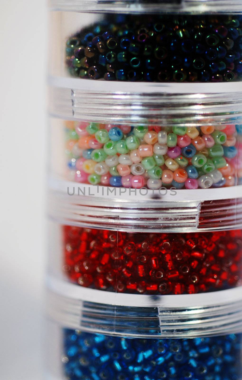 A close up photograph of four pots of seed beads for craft