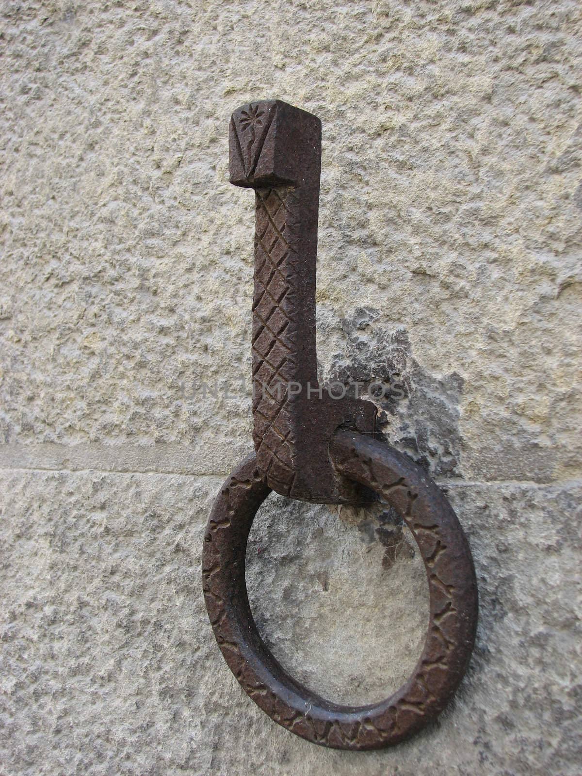 Closeup of old stucco wall surface with metal ring

