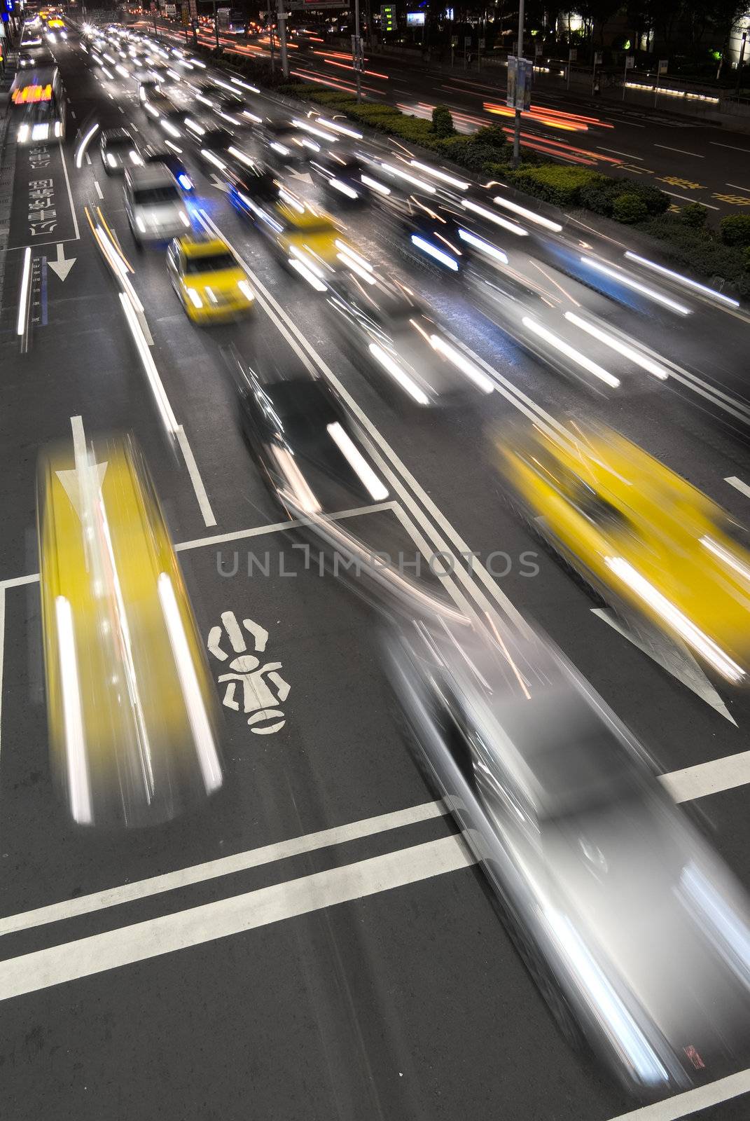Cars motion blurred in modern city night.