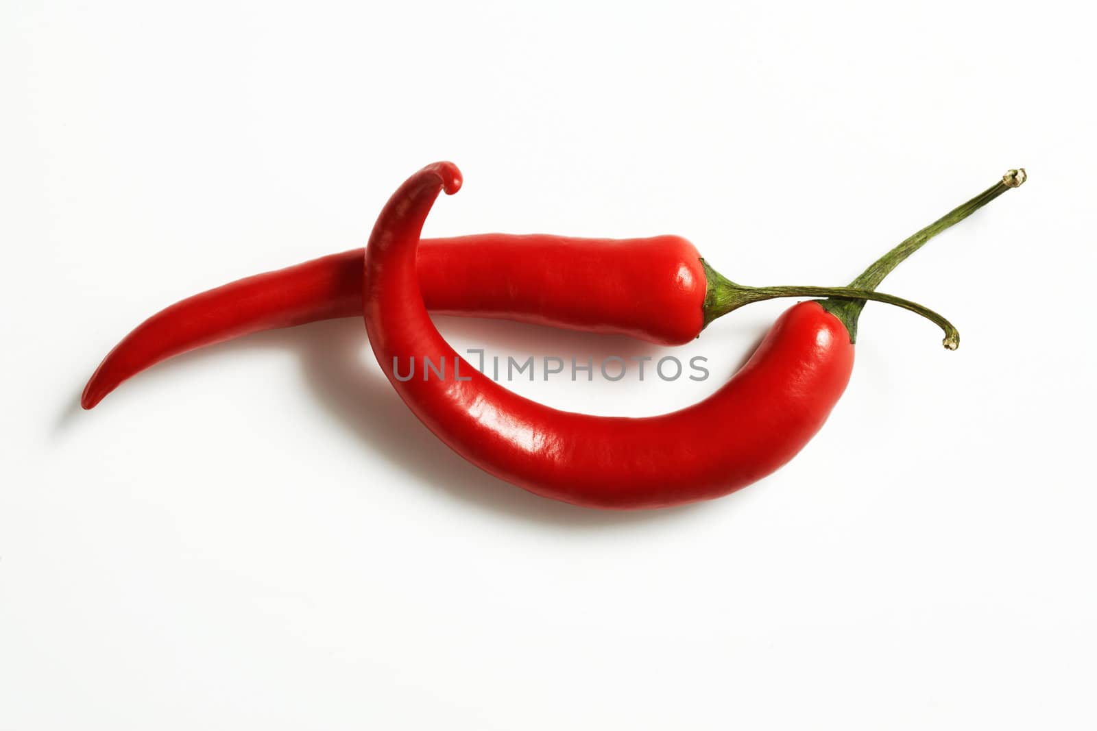 Perfectly fresh red hot peppers on white. The file includes a clipping path.  Professionally retouched high quality image.