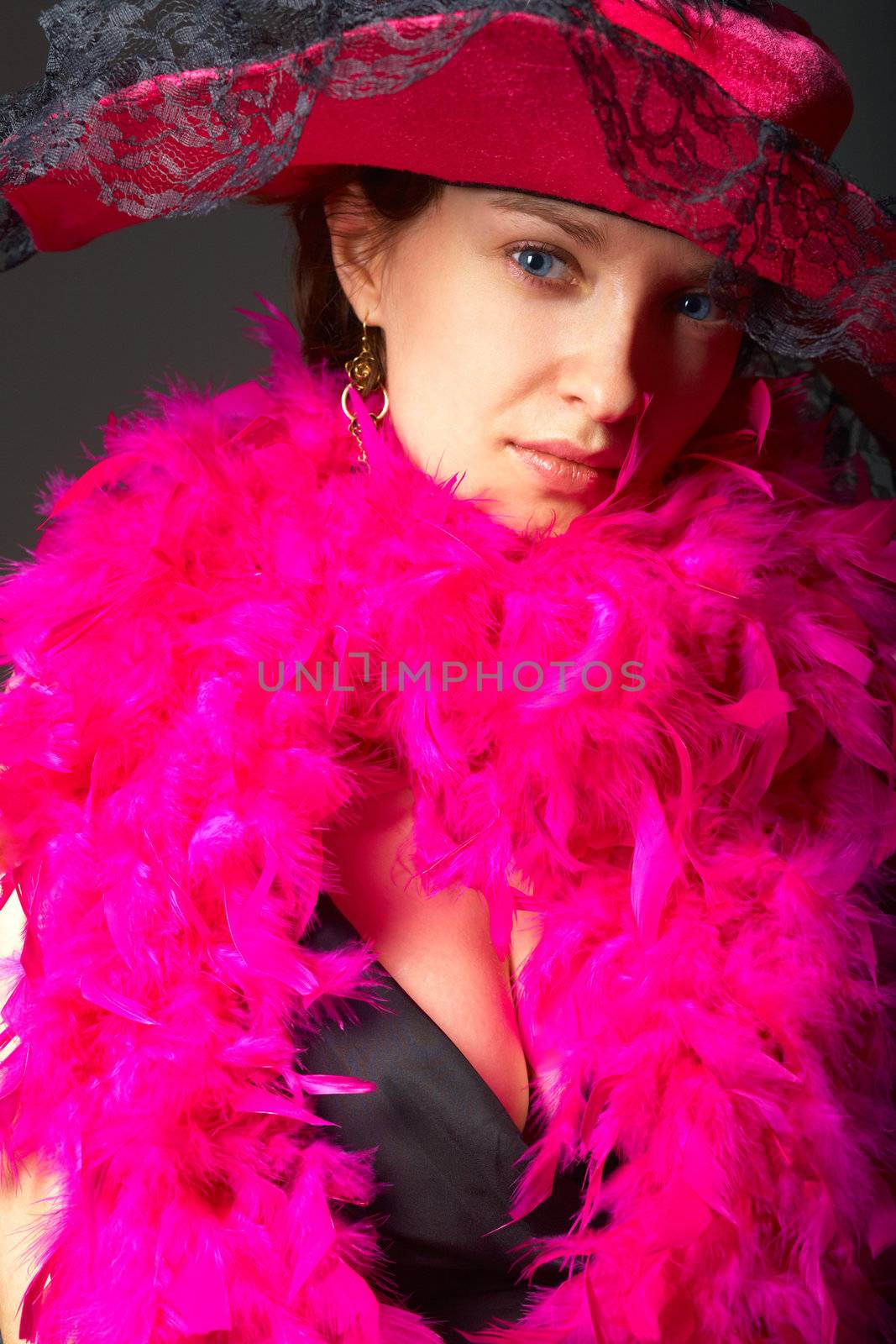 Beautiful woman in pink feathers and hat. Close-up view