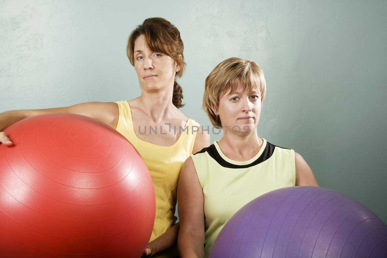 Two Physically Fit Women Posing With Exercise Balls