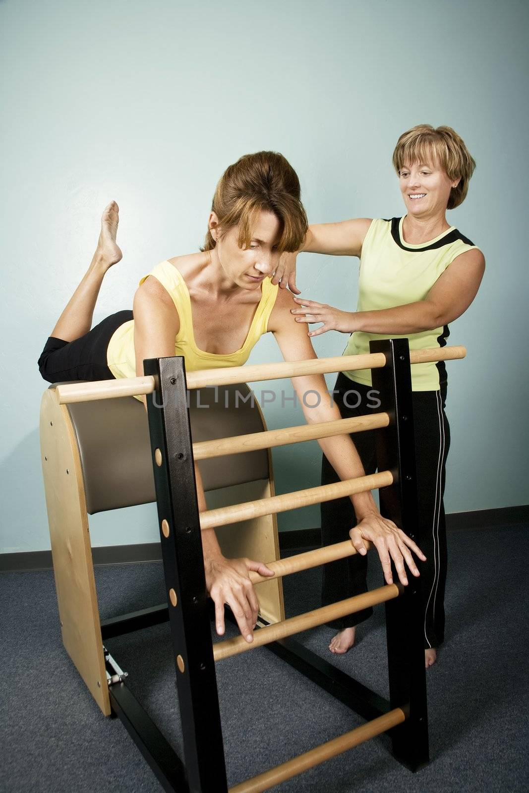 Personal Trainer Supervises a Woman Working Out on Equipment