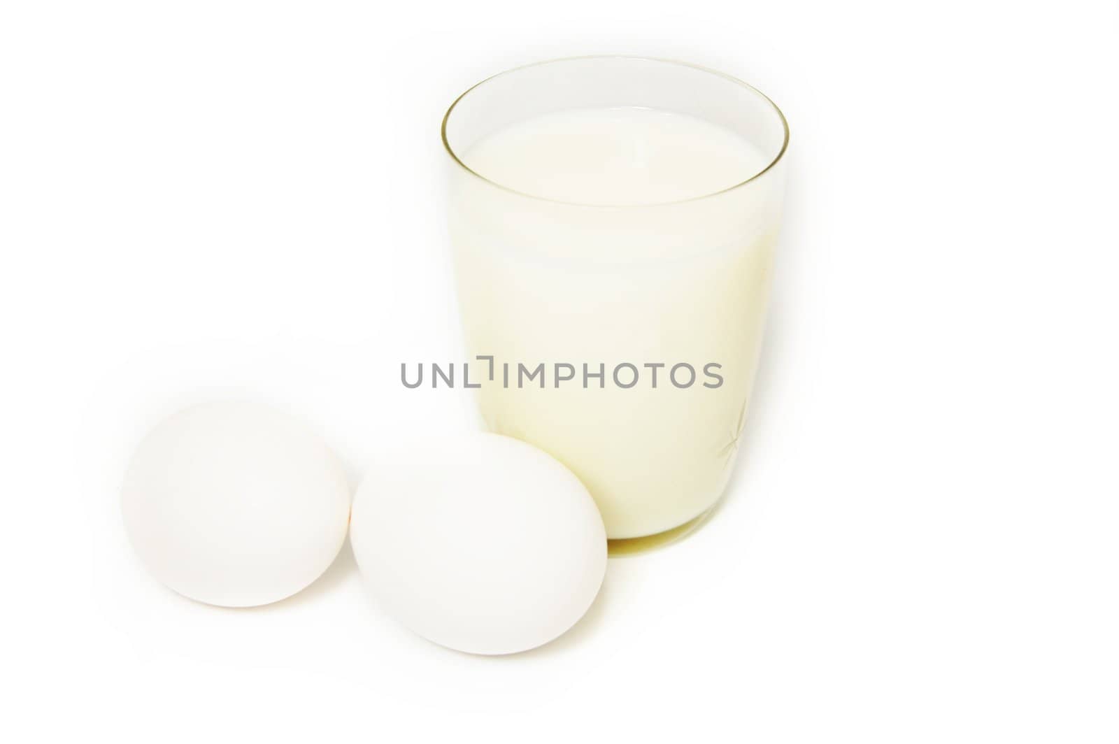 Glass of milk and eggs on white