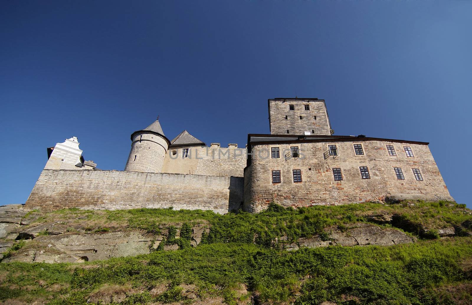 Kost Castle - large Gothic castle - is located in the Ji��n District of the Czech Republic. "Kost" is "bone" in Enhlish - as hard as  bone. 
In Northern Bohemia, specifically the region Bohemian Paradise lies Kost Castle, first proposed by Benes von Wartenberg in 1349 as a possible construction site. It was completed by his son Peter von Wartenberg and since then it has not been changed and is still in good repair.
The castle is known for its so-called "White tower". In about 1414 the family of Zaj�c von Hasenburg moved there; later the family of Schellenberg (1497 - 1524), Lobkowicz (till 1576) and others; in this time some more buildings were built near the castle and joined to it.
Unlike most other castles in Bohemia, it does not lie on a hill, but on a spit between two brooks. Another peculiarity is the tower, which has a trapezoid-like ground-plan. Like in some other cases, the reason was that if an artillery shell was fired, it would not hit the wall at a right angle (the angle of greatest possible damage).

