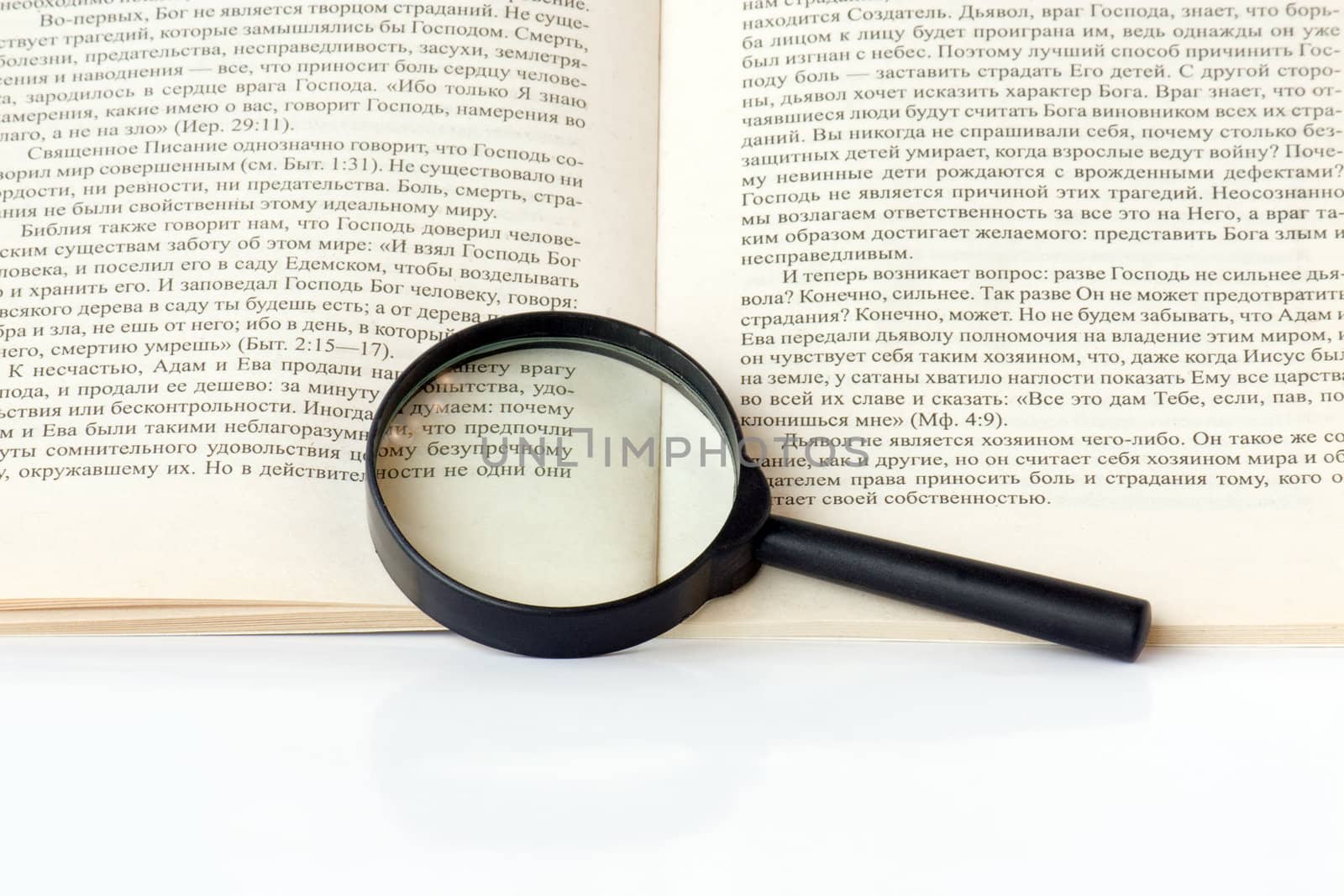 A magnifying glass is on the page of the book.