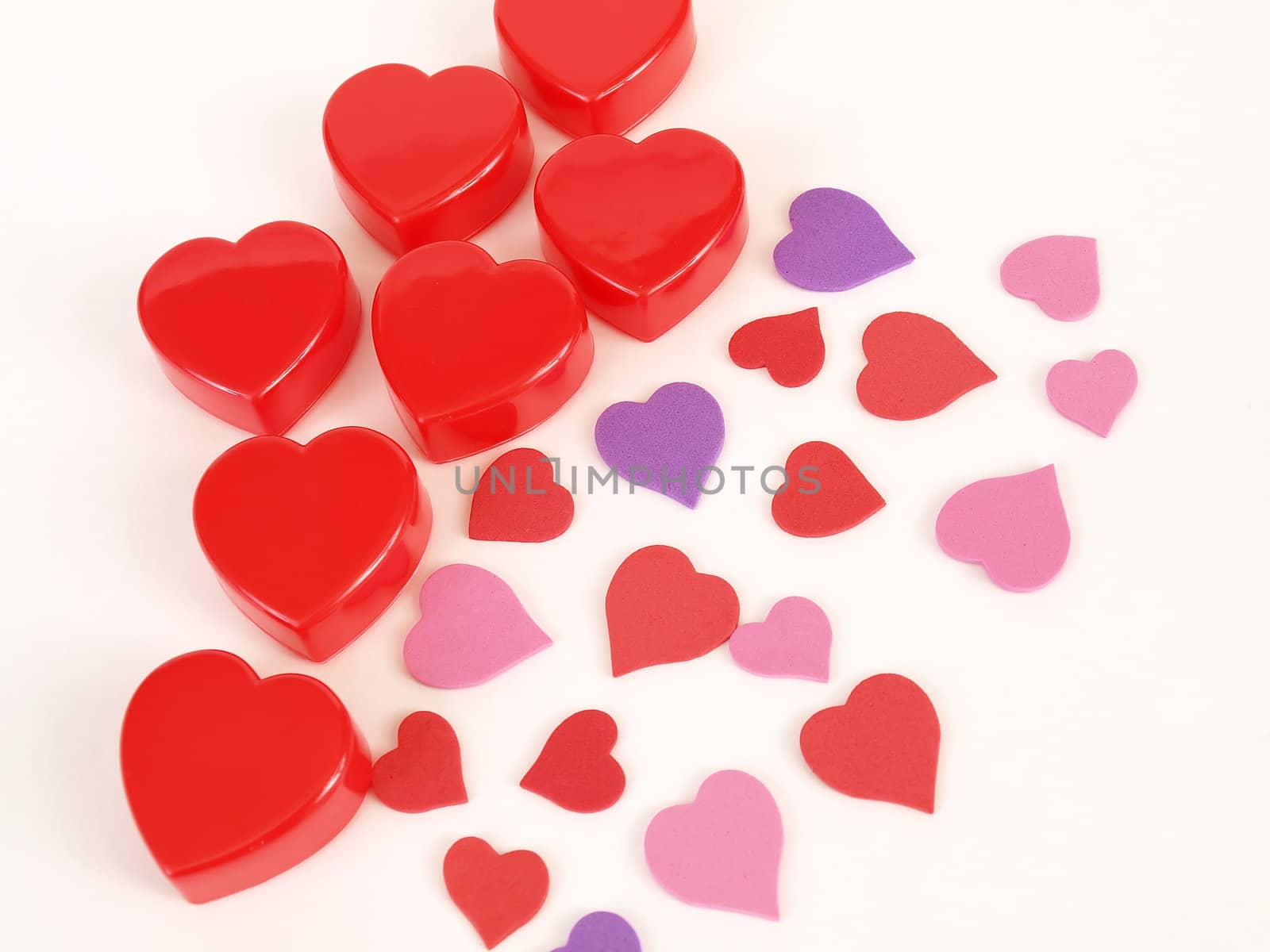 Assorted heart shapes in reds and purples arranged against a white background.