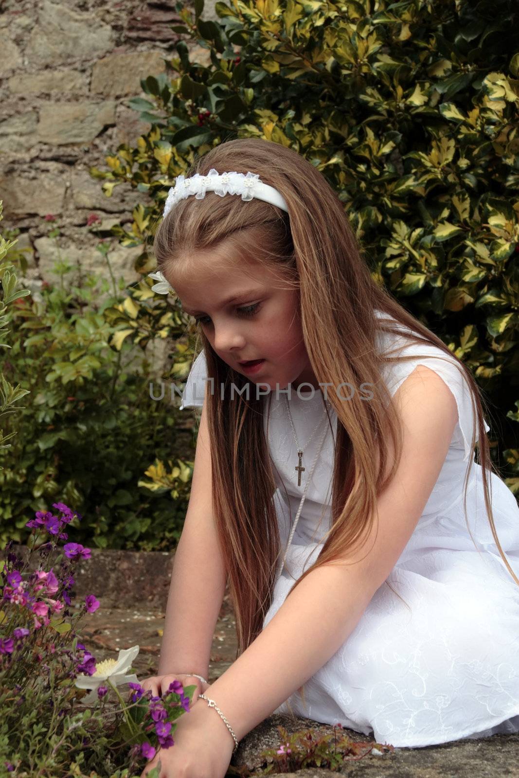 portrait of a young girl on her first communion in ireland picking flowers