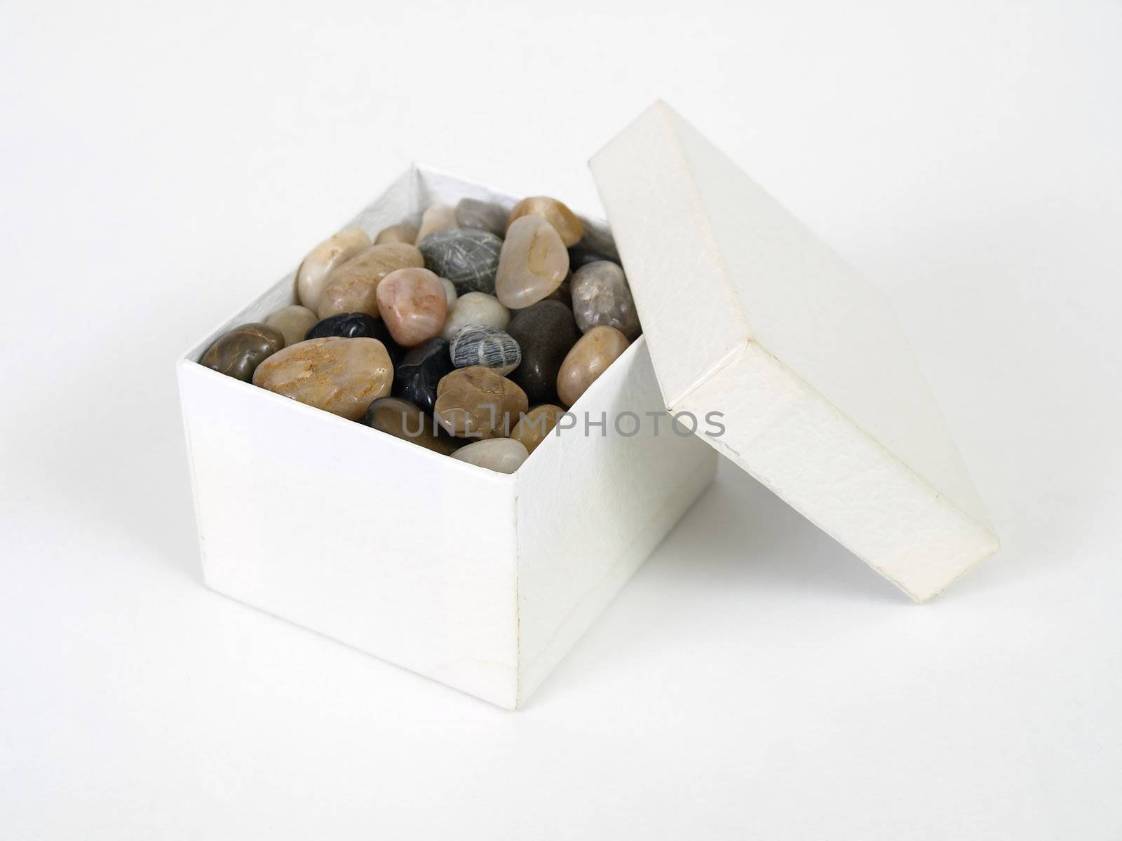 A box of nicely polished stones in a box isolated on a white background.