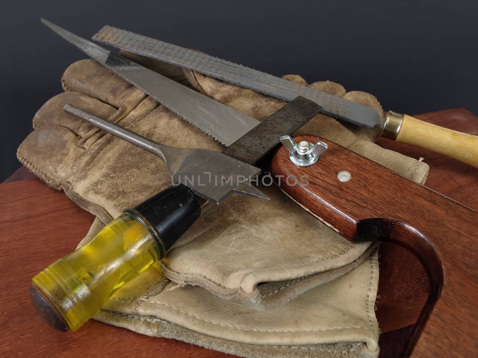 Small hand tools for woodworking, with a pair of leather gloves.