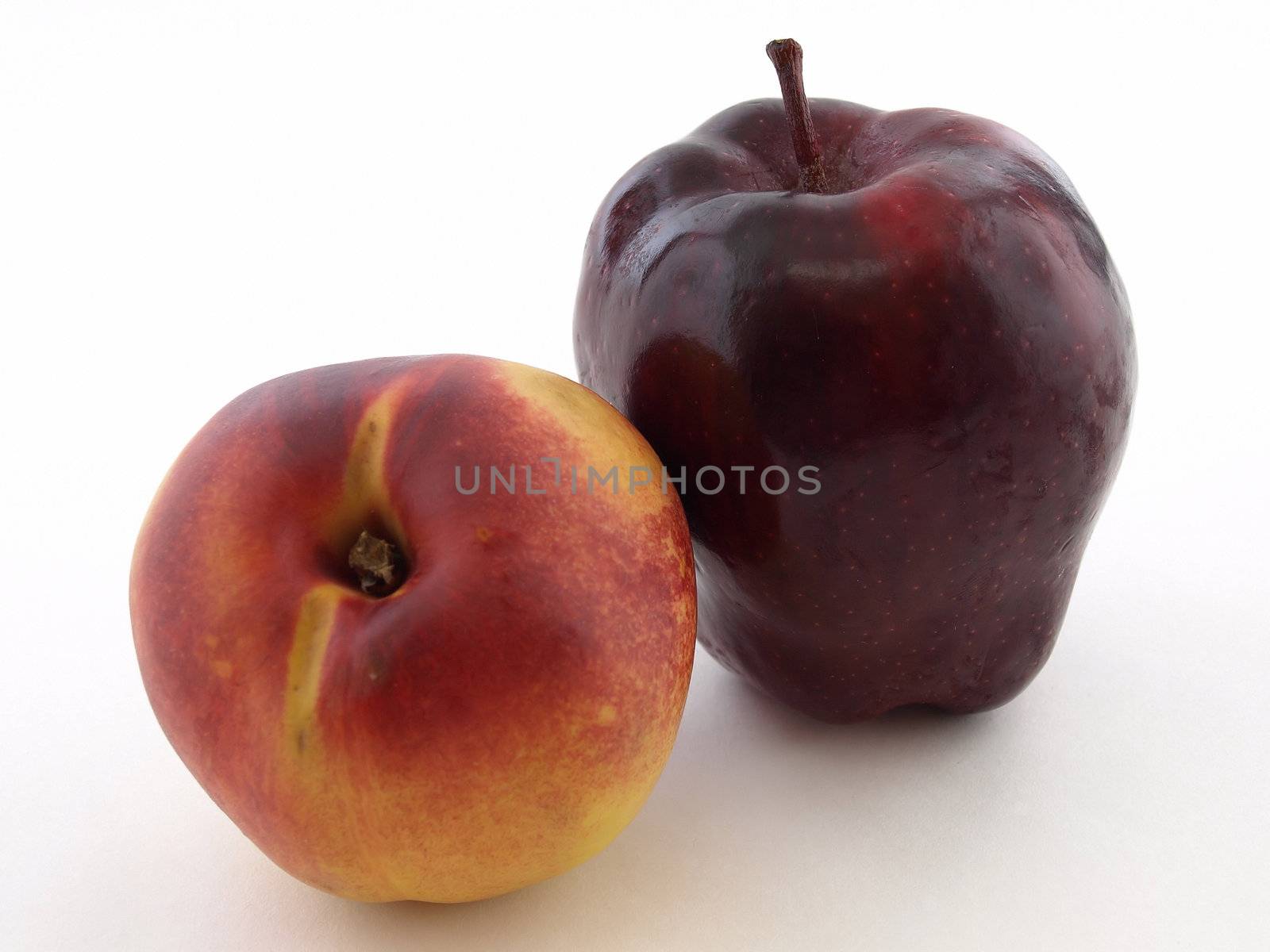 Ripe juicy peach and crisp red apple isolated against a white background