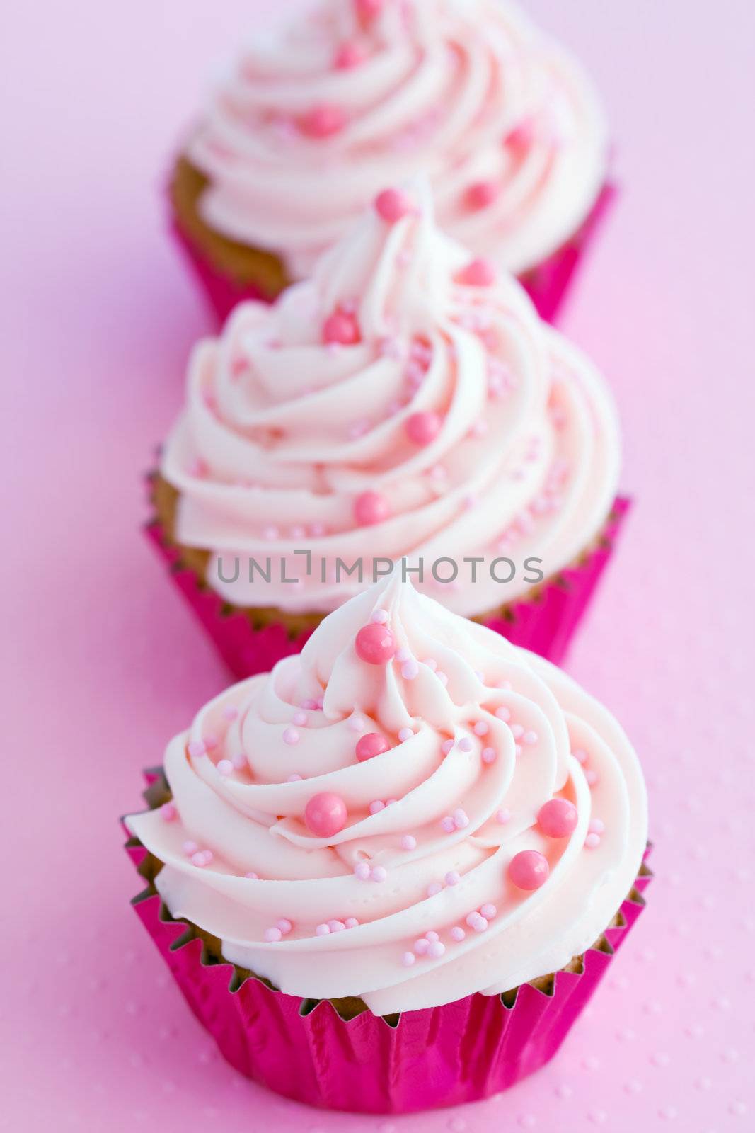 Pastel pink cupcakes in magenta foil wrappers