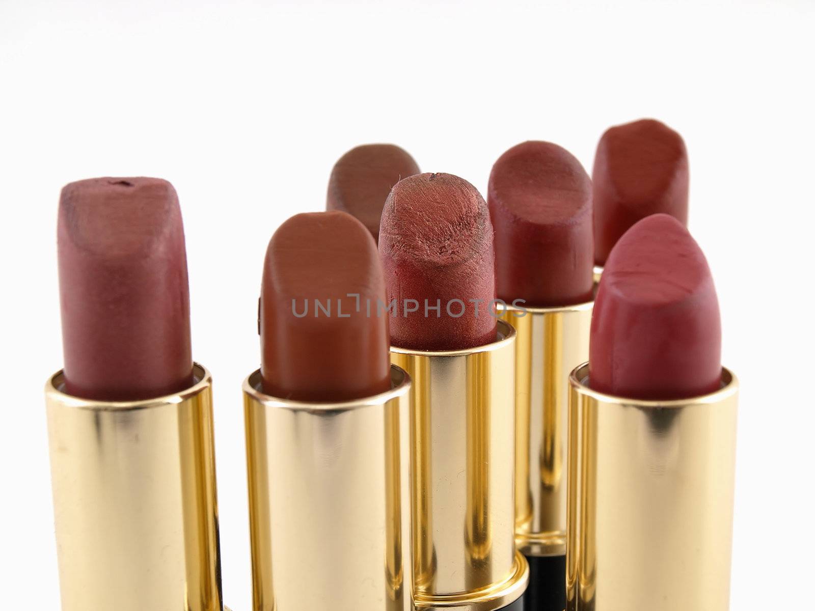 Several different red colored lipstick tubes isolated on a white background