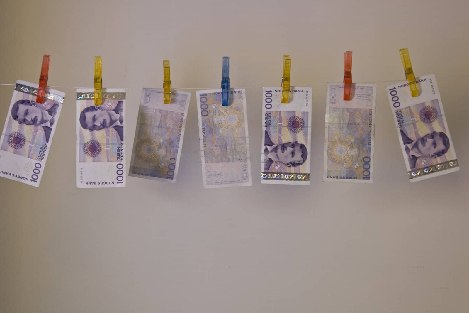 Illustration with the highest denomination of bank notes in Norway, hanging on a clothes hanger with clothes-pegs. Could illustrate money laundering and illegal business, but also a good illustration for wealth and money. 