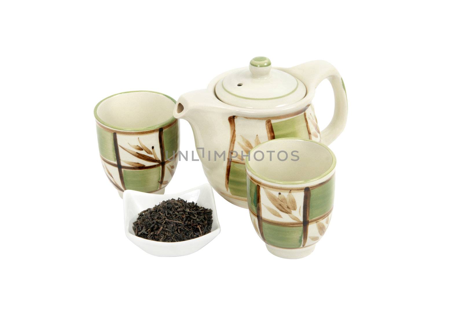A porcelain tea set comprising one decorated teapot, two decorated teacups and a container holding shredded tea leaves on white background. Clipping path included.
