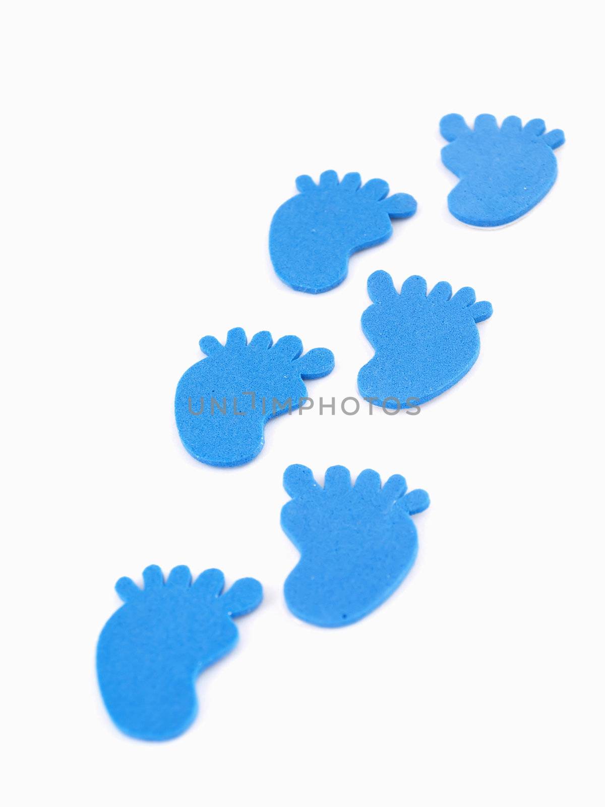 6 blue foam footprints in a trail isolated on a white back ground