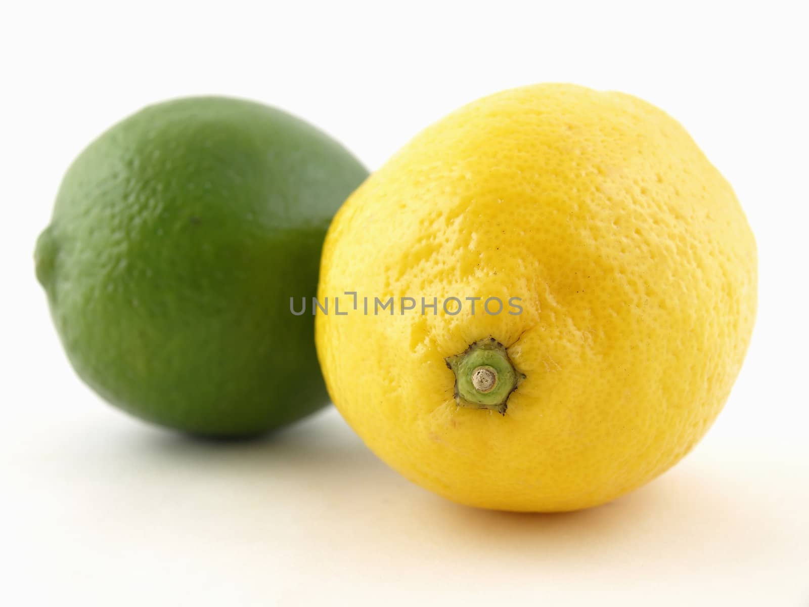 A green lime and a yellow lemon isolated on a white background