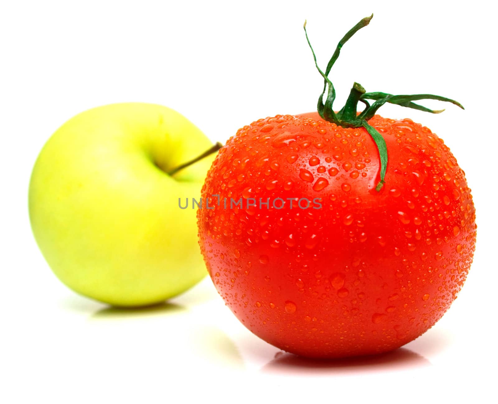 Yellow apple and tomato. Shallow DOF. Focus on a red tomato.