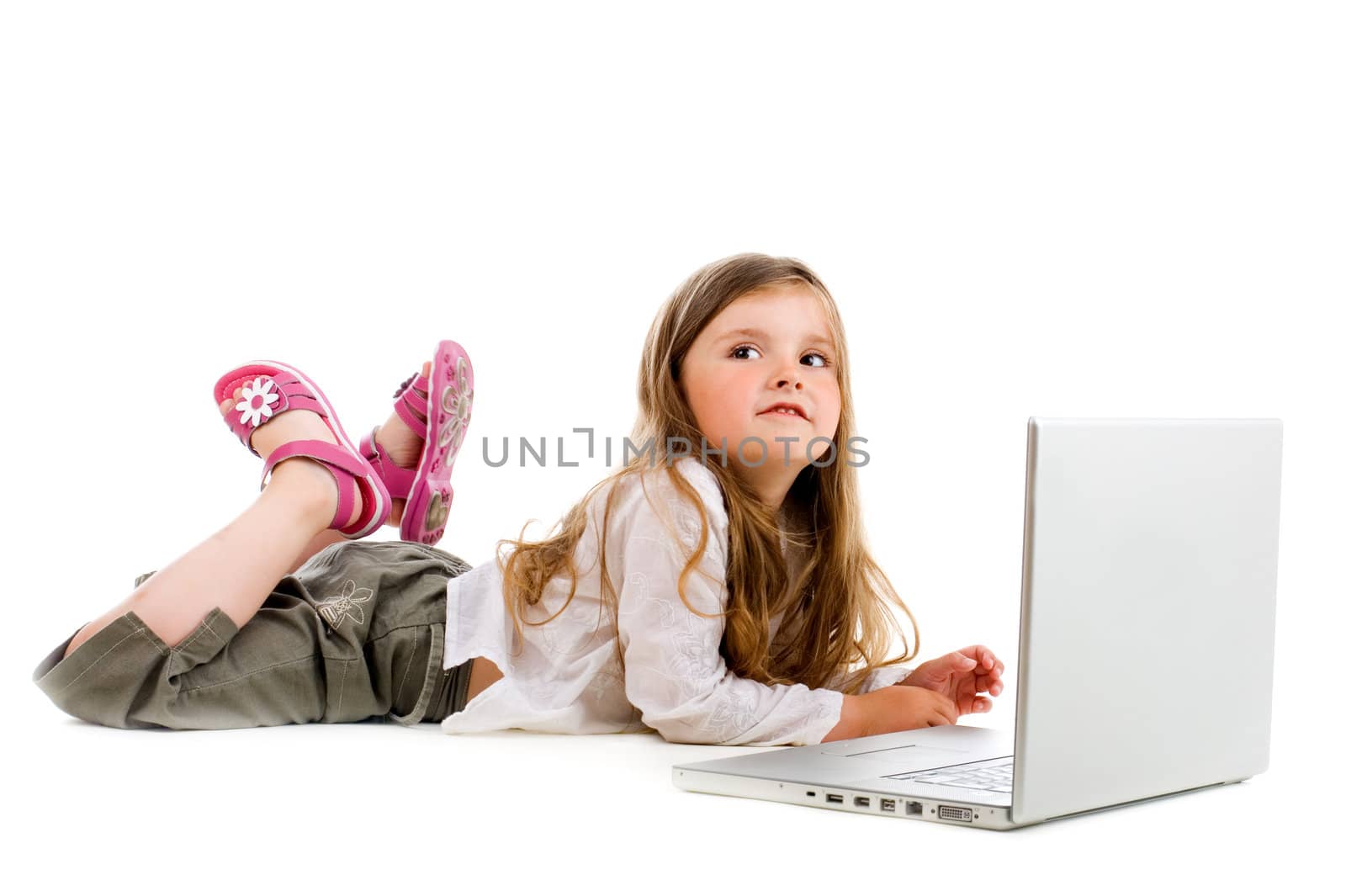Adorable caucasian little girl lying with laptop