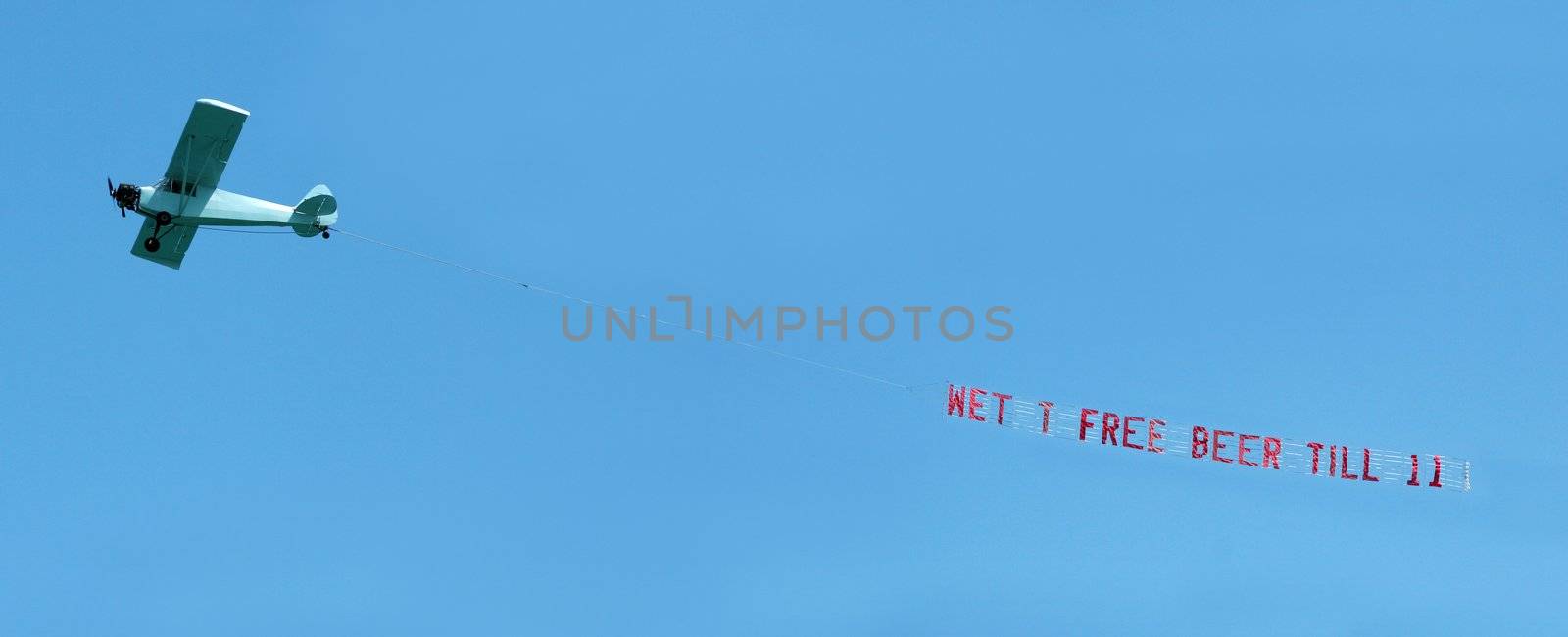Small airplane towing a spring break banner message through the air