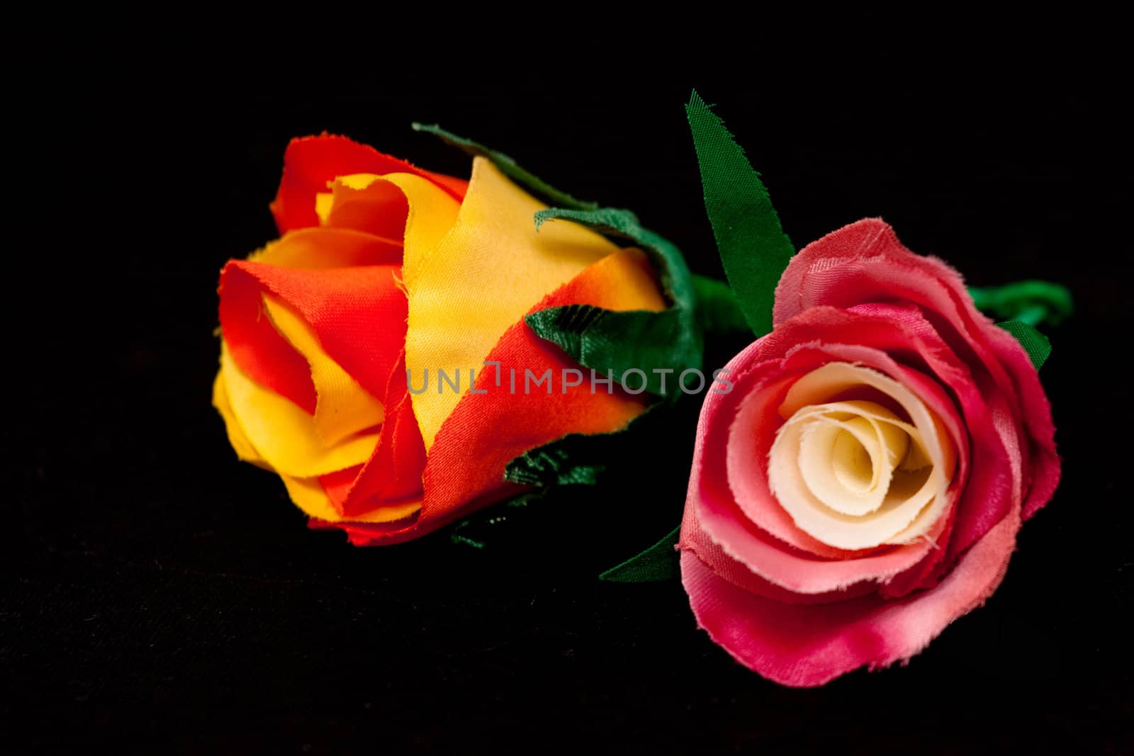 two artificial handmade roses on black
