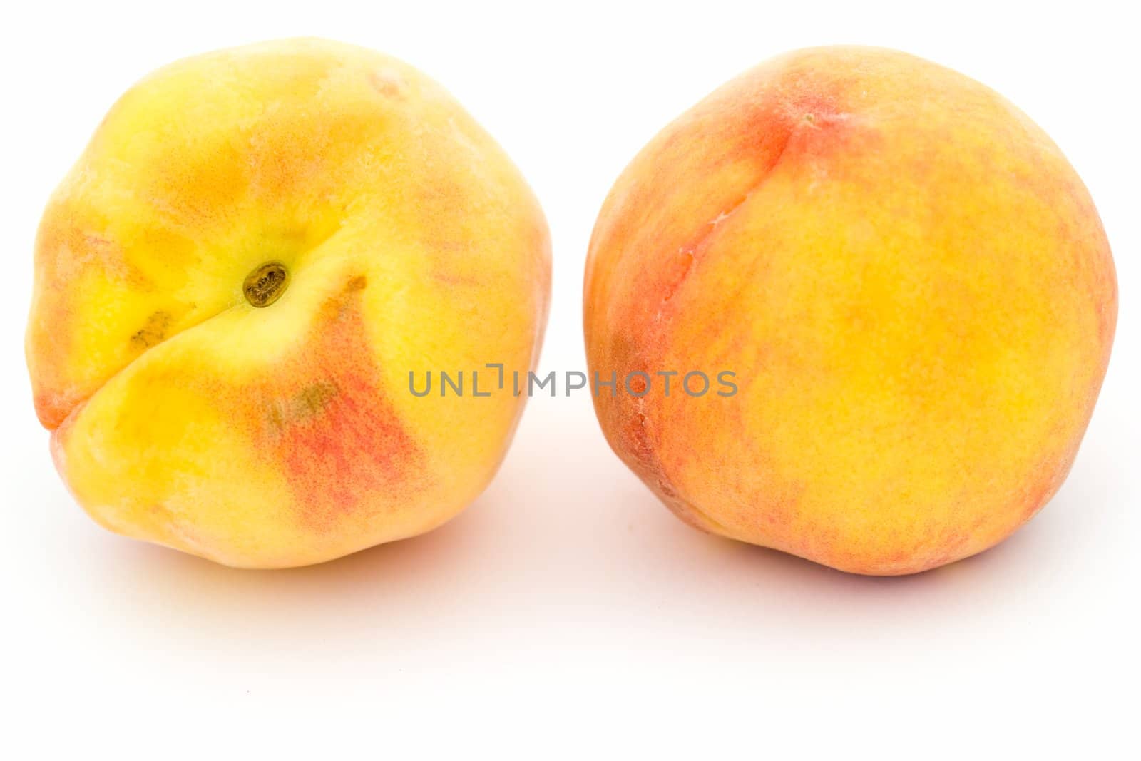 Two ripe peaches on a white background