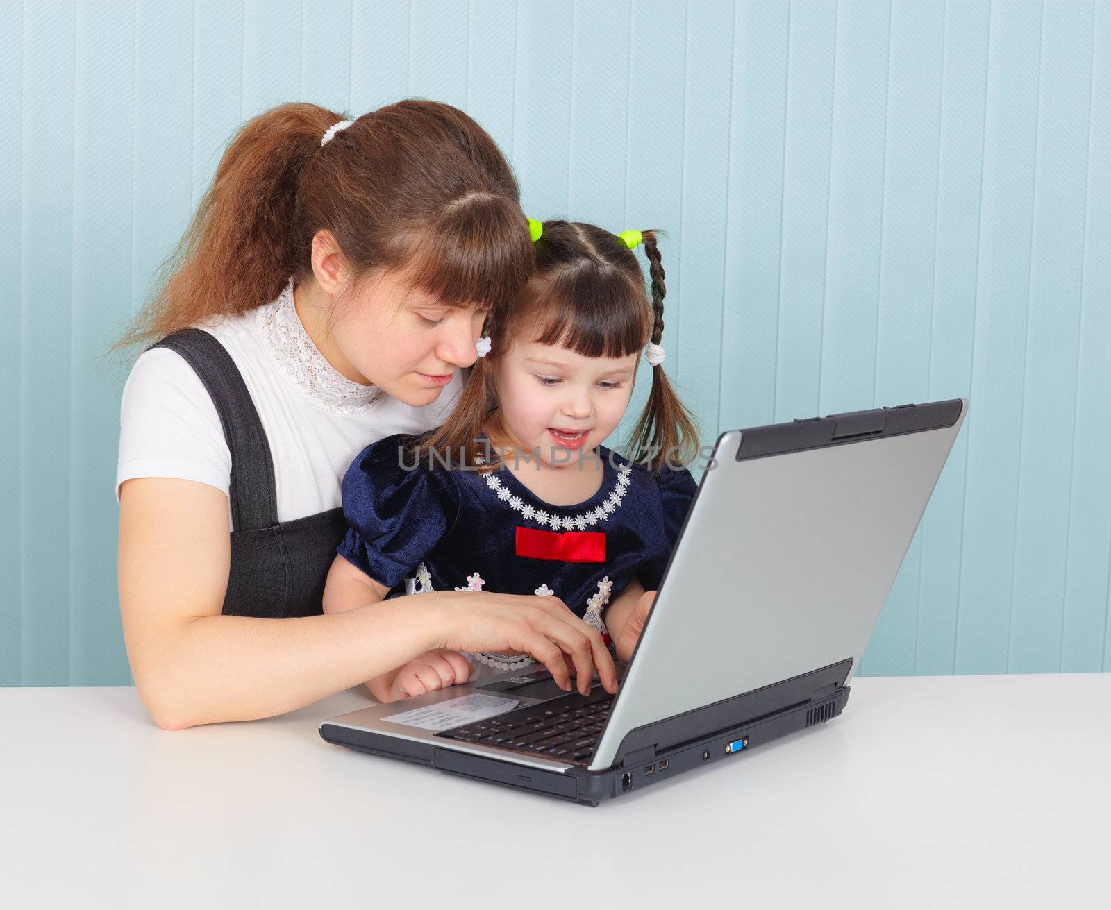 His mother teaches the child to use laptop