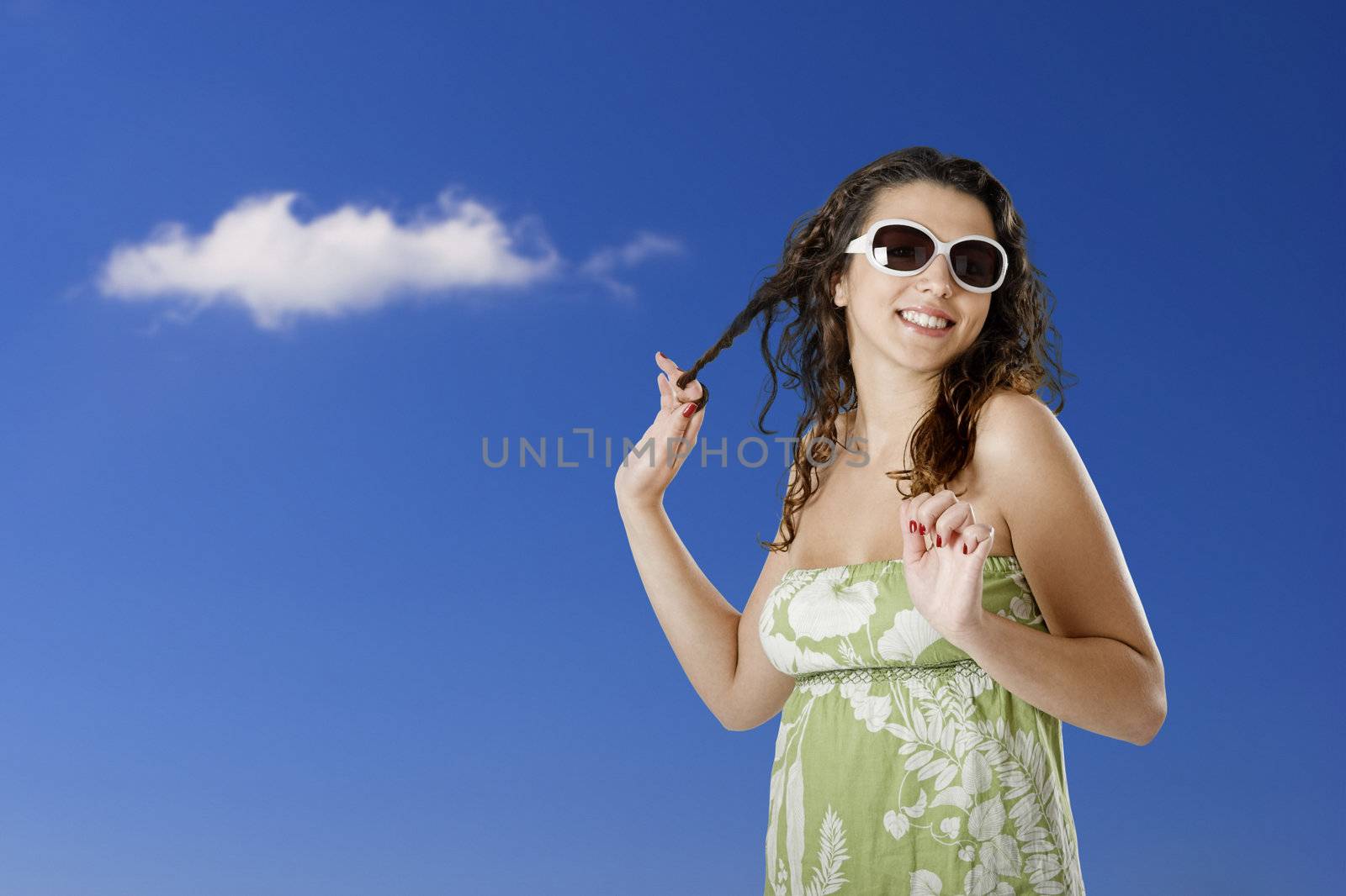 Portrait of a beautiful young woman posing with a cloudy sky in the back
